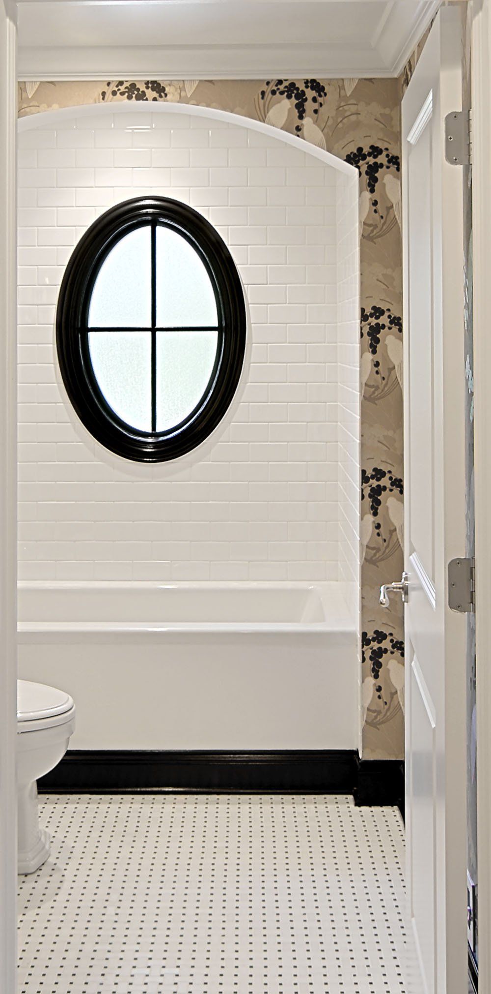 A bathroom with a round window on the wall.