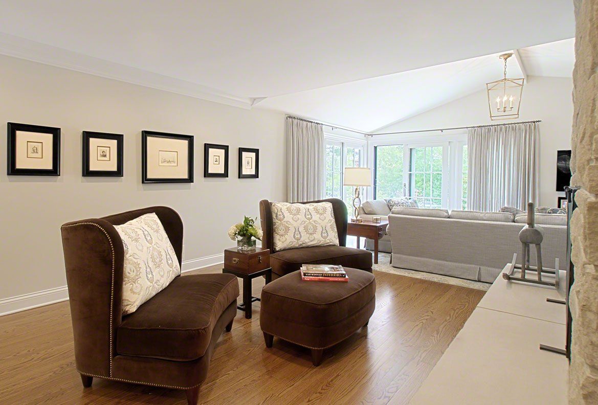 A living room with a couch , chairs , and ottoman.