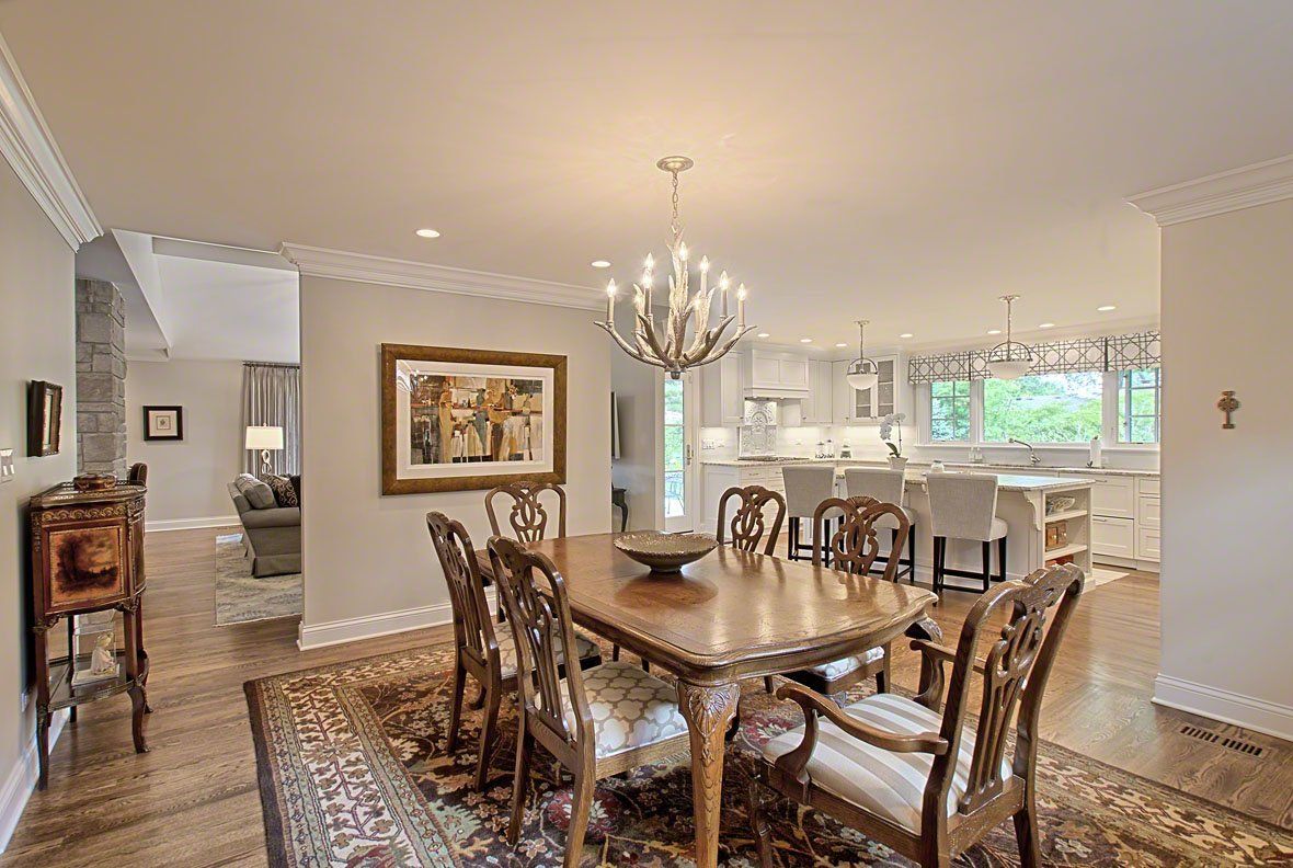 A dining room with a table and chairs and a chandelier.