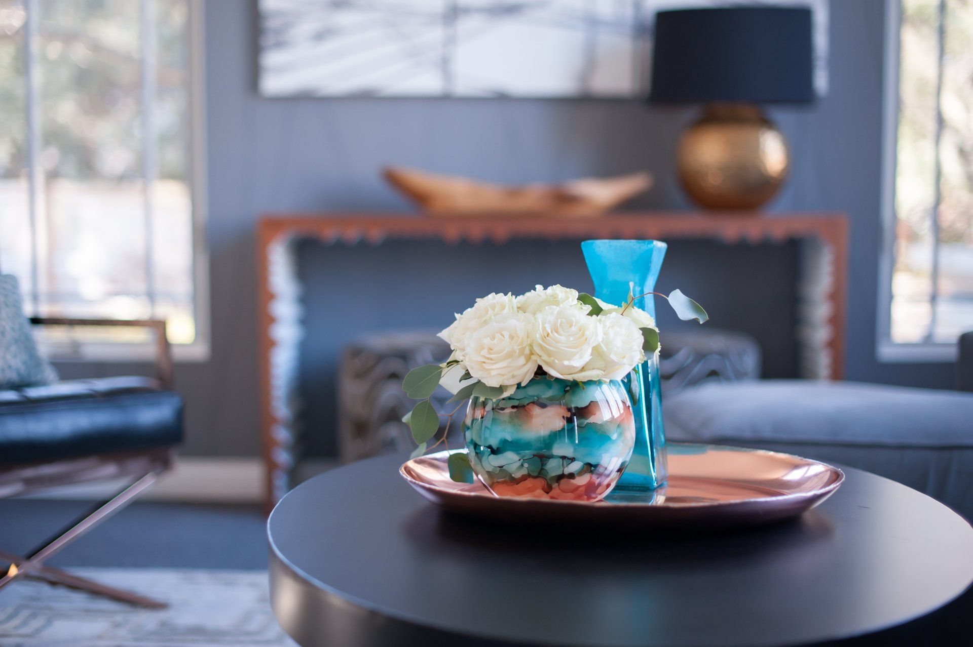 A table with a vase of flowers on it in a living room.