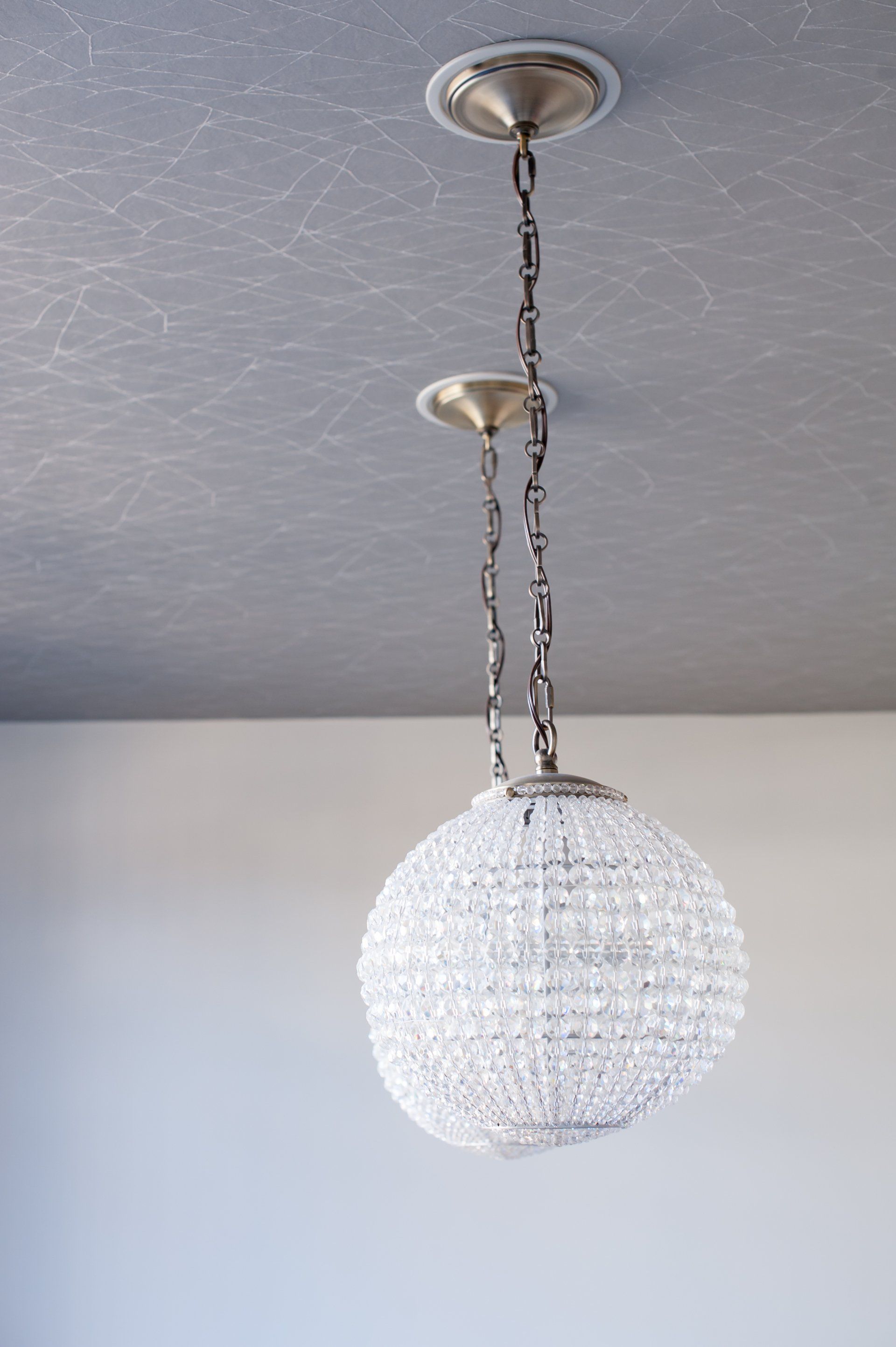 A crystal chandelier is hanging from the ceiling in a room.