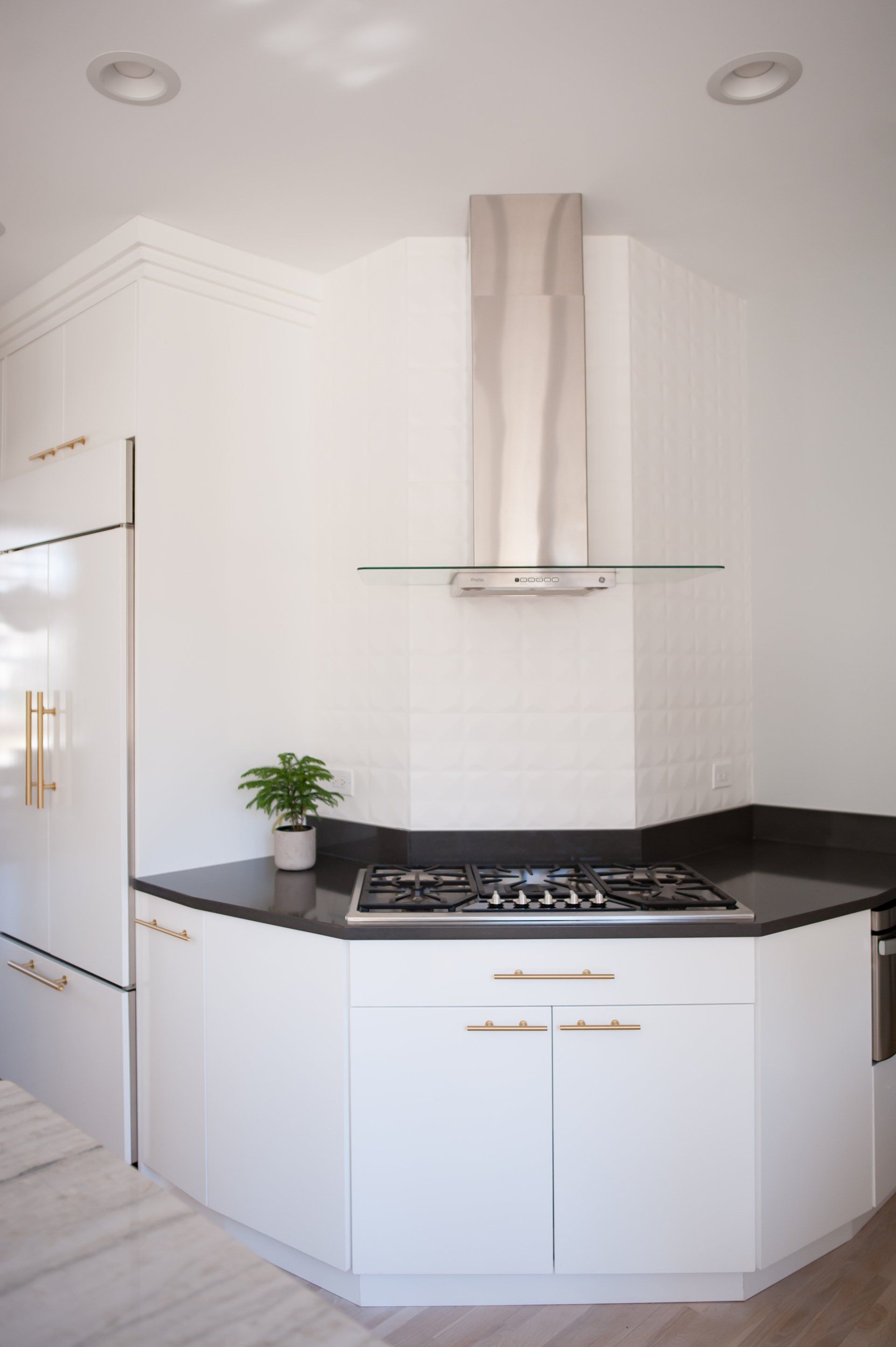A kitchen with white cabinets and a stove top oven