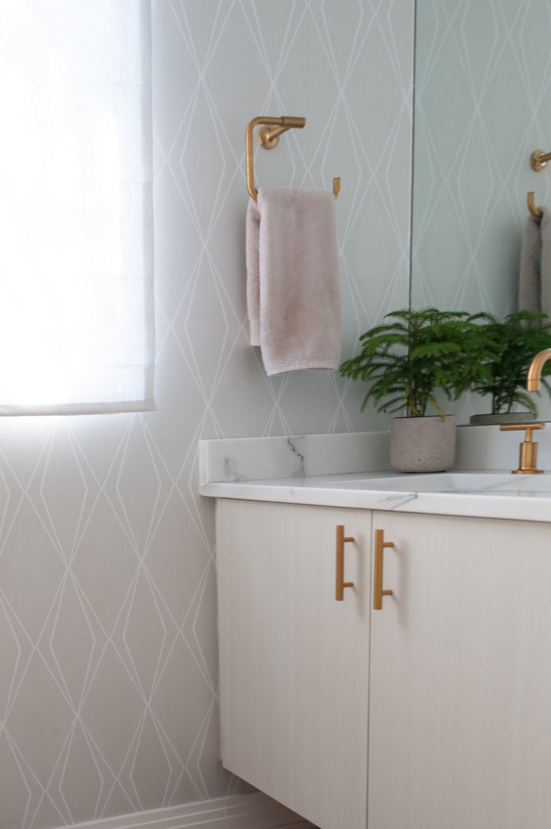 A bathroom with a sink , mirror and towel rack.