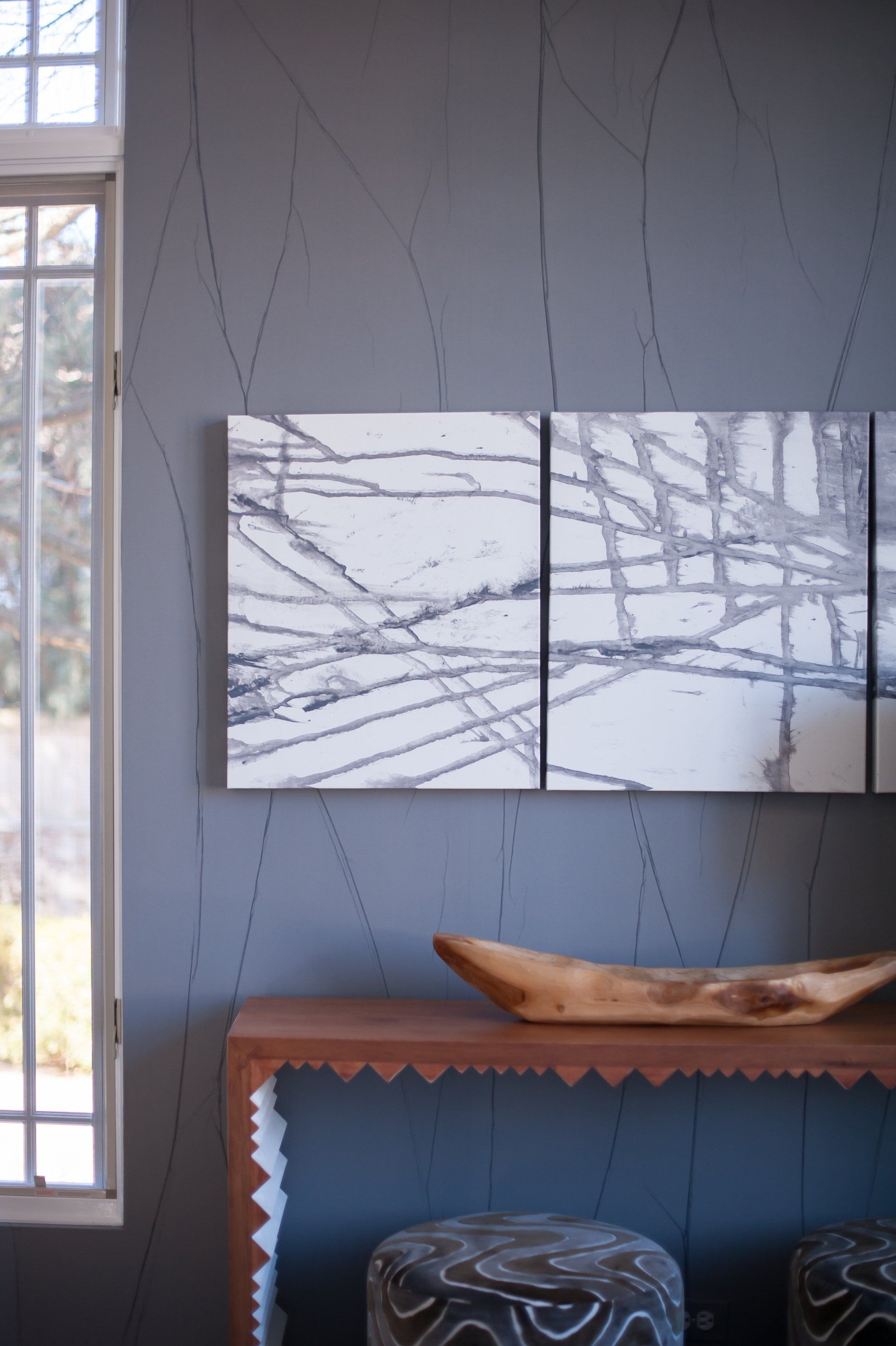 A painting is hanging on a wall above a wooden table