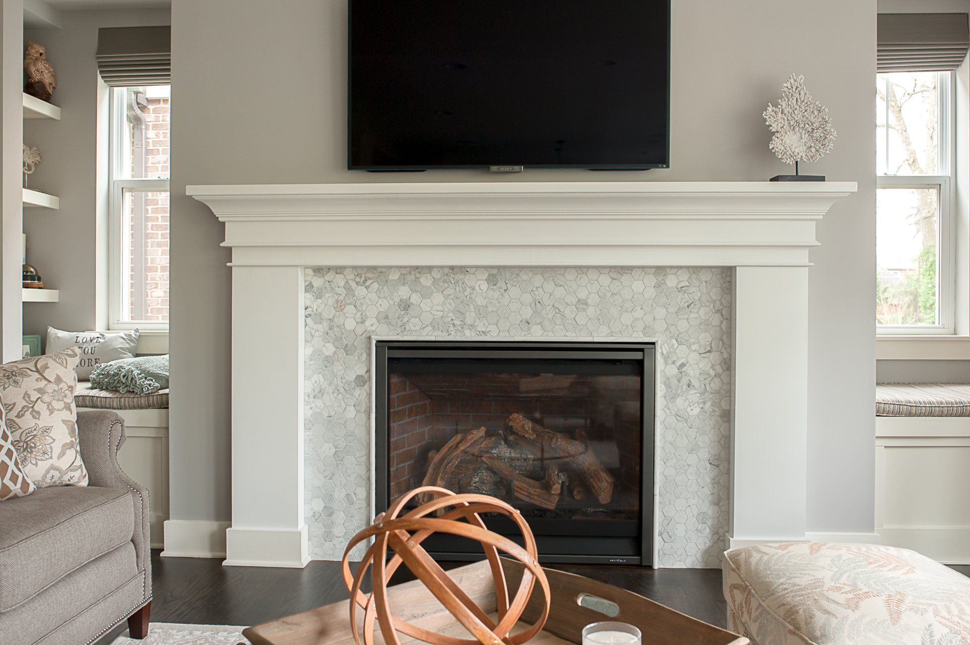 A living room with a fireplace and a flat screen tv above it.