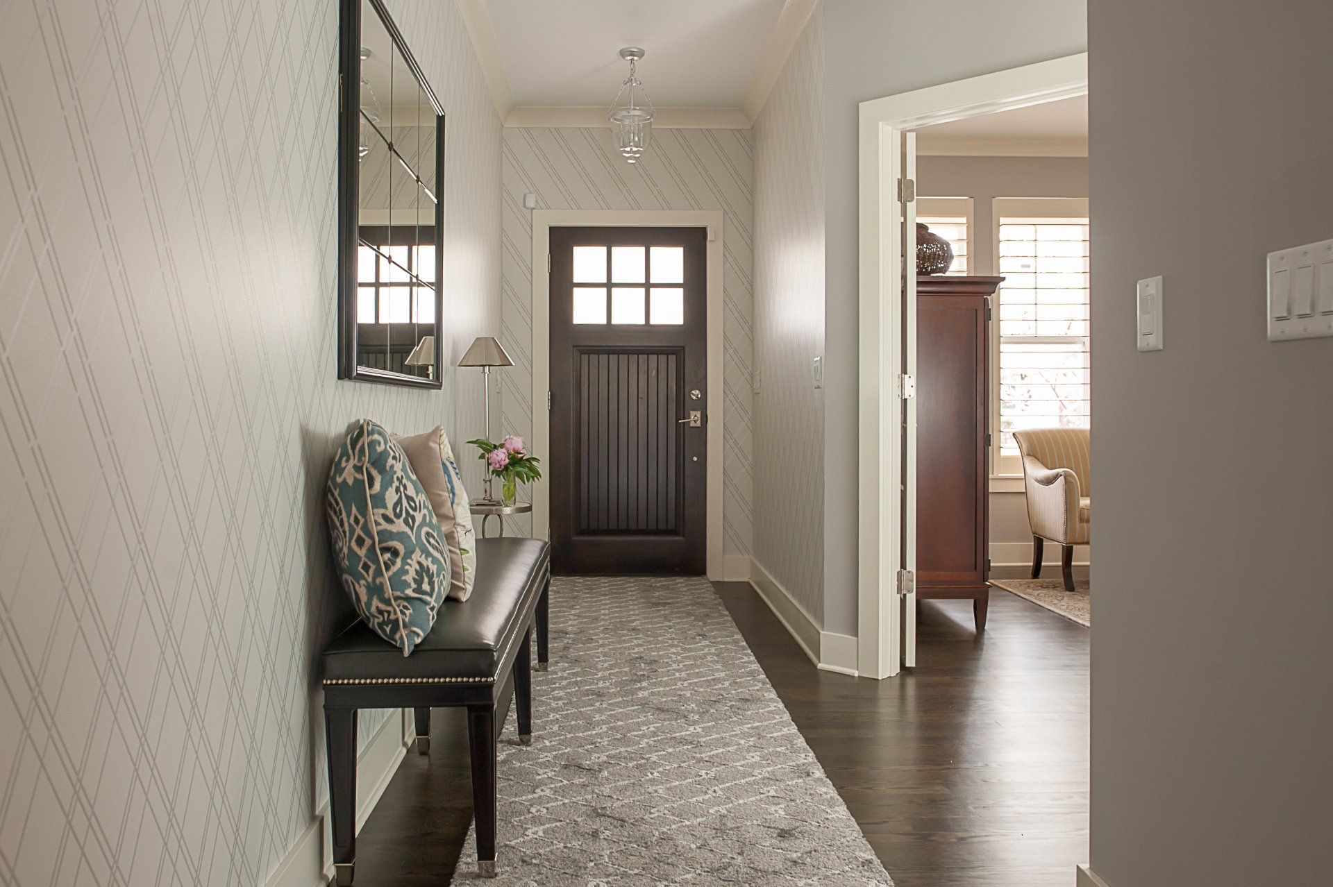 A hallway with a bench and a mirror on the wall