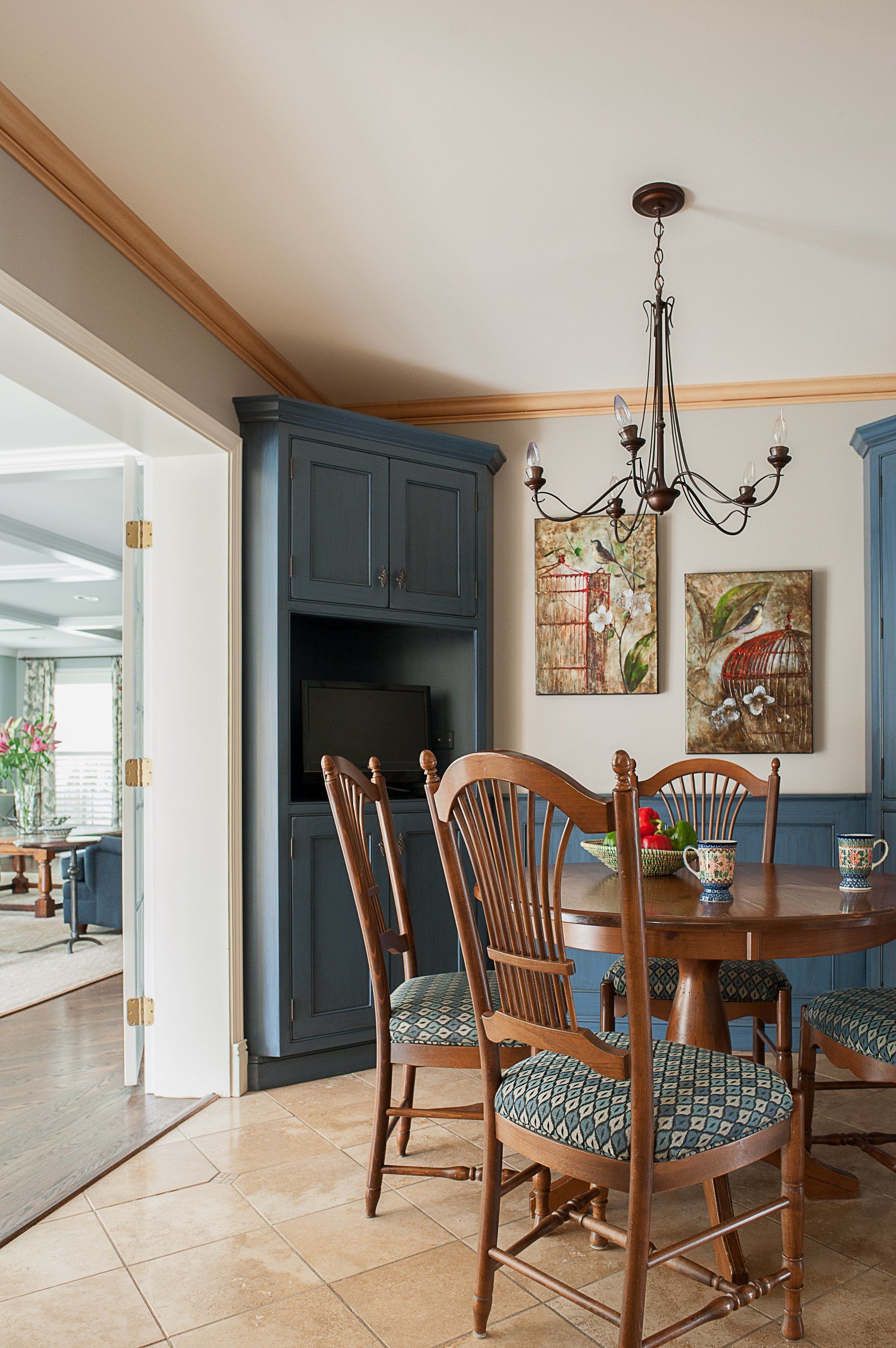 A dining room with a table and chairs and a chandelier.