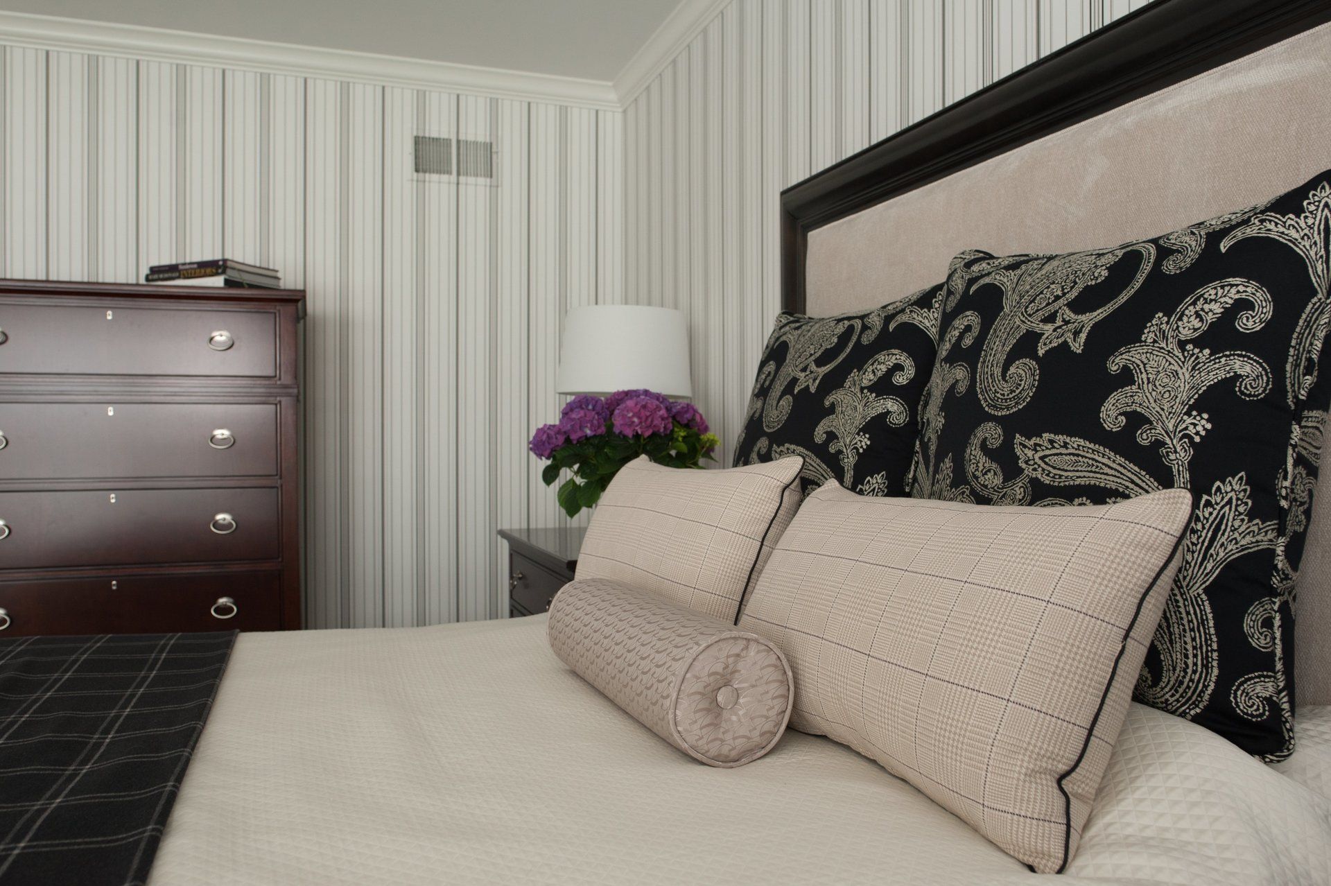 A bedroom with a bed dresser and lamp