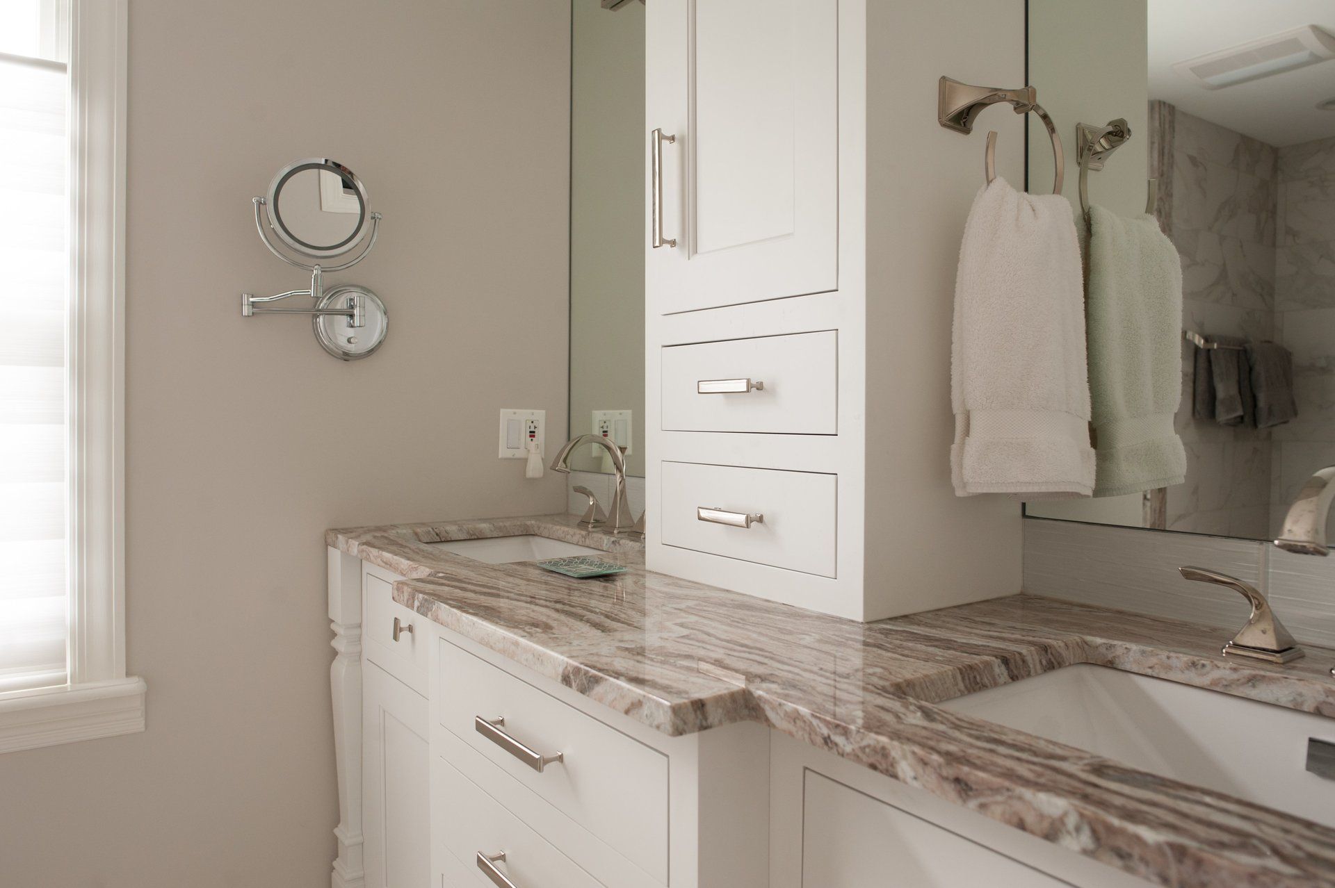 A bathroom with two sinks , a mirror and a window.