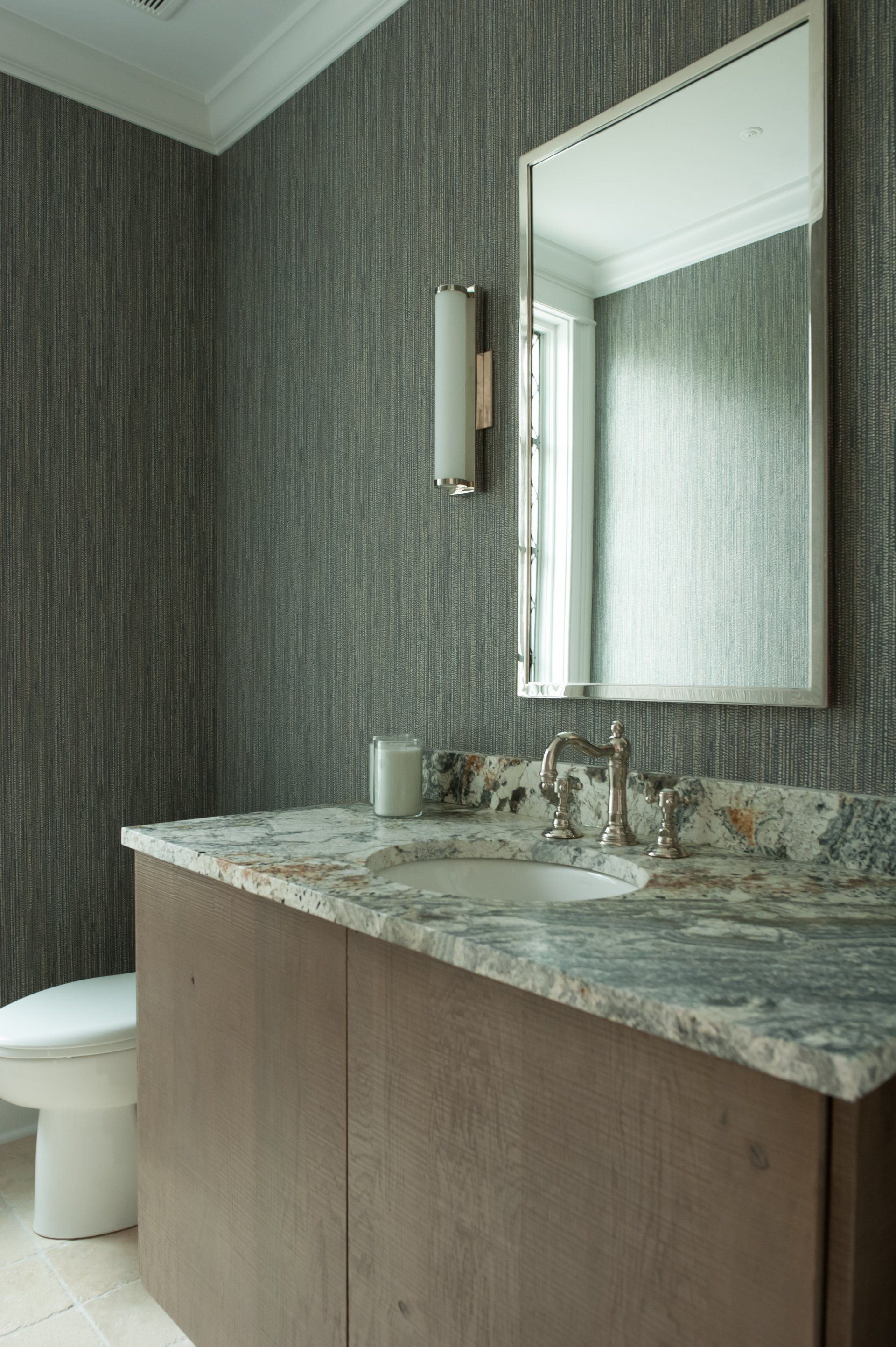 A bathroom with a sink , toilet and mirror.