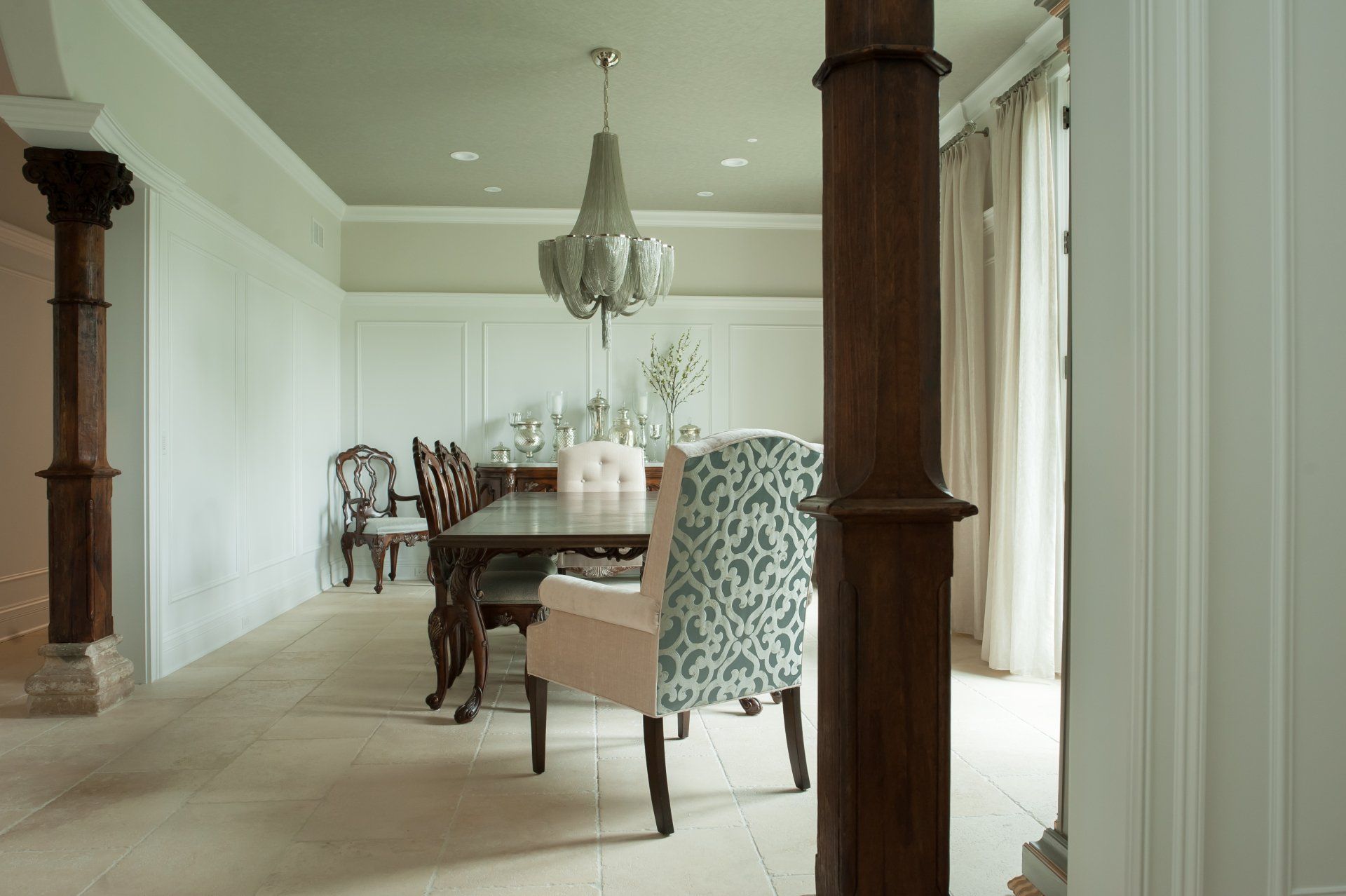 A dining room with a table and chairs and a chandelier
