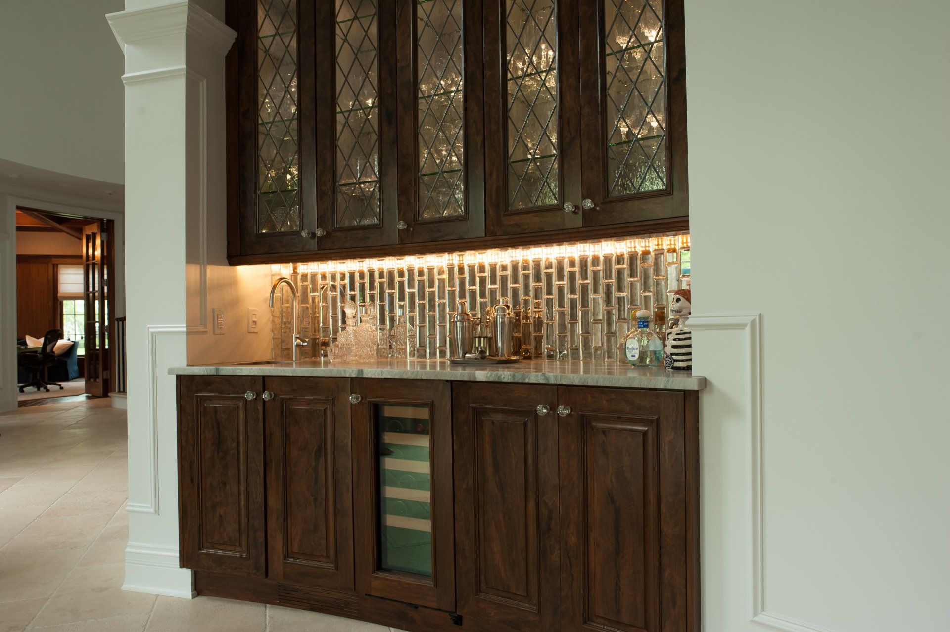 A kitchen with a bar and a refrigerator in it.