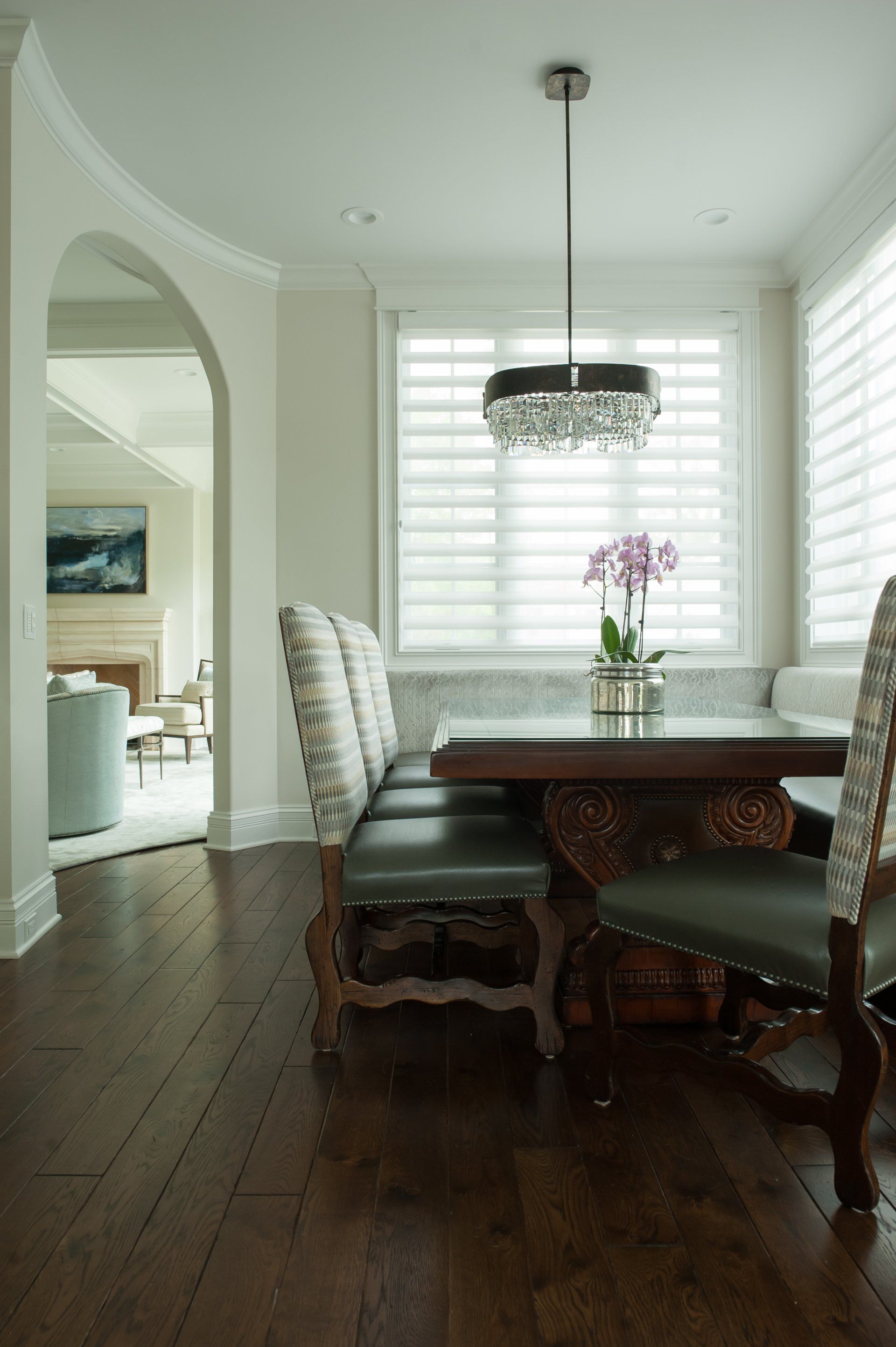 A dining room with a table and chairs and a window.