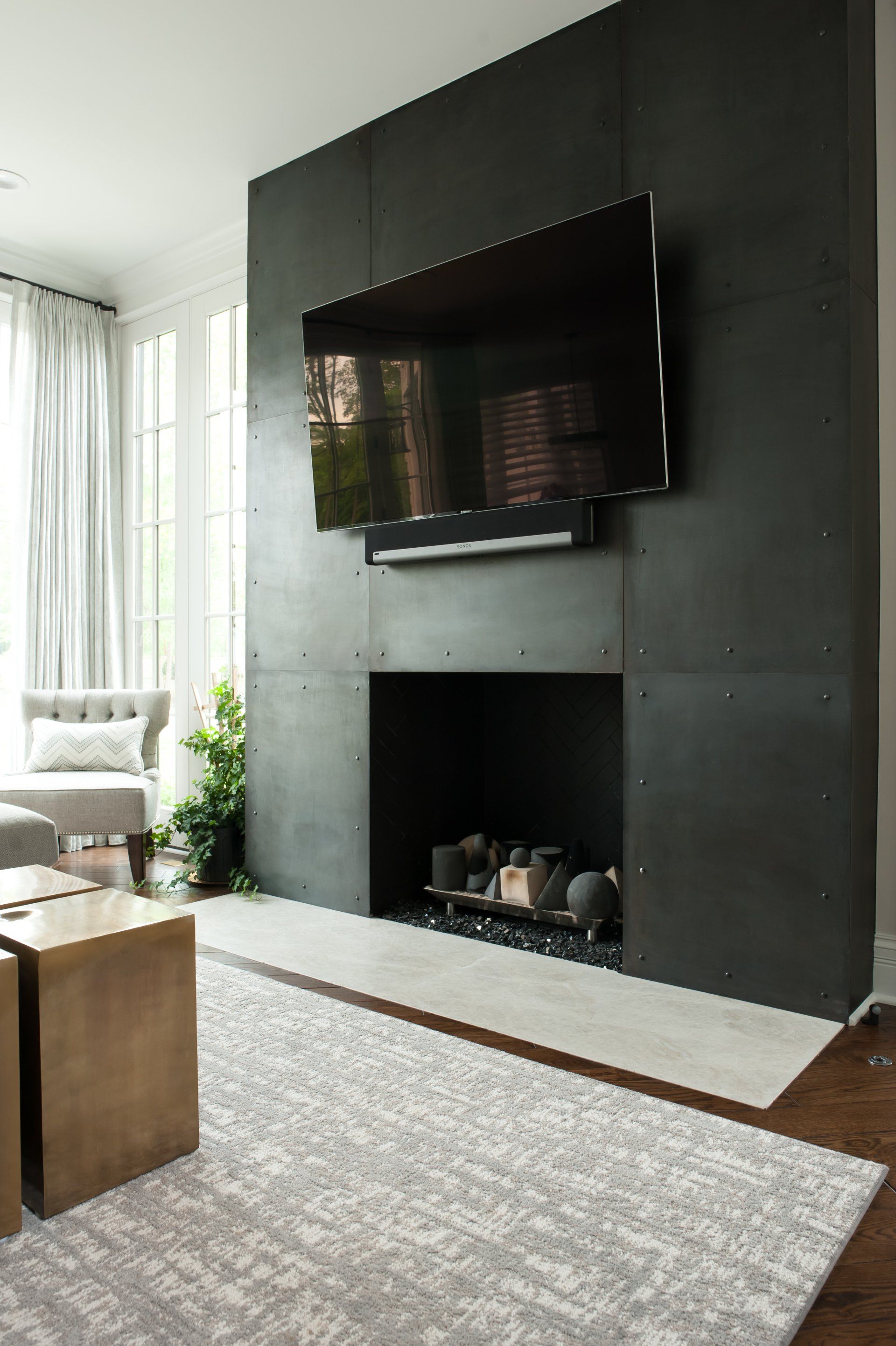 A living room with a fireplace and a flat screen tv on the wall.