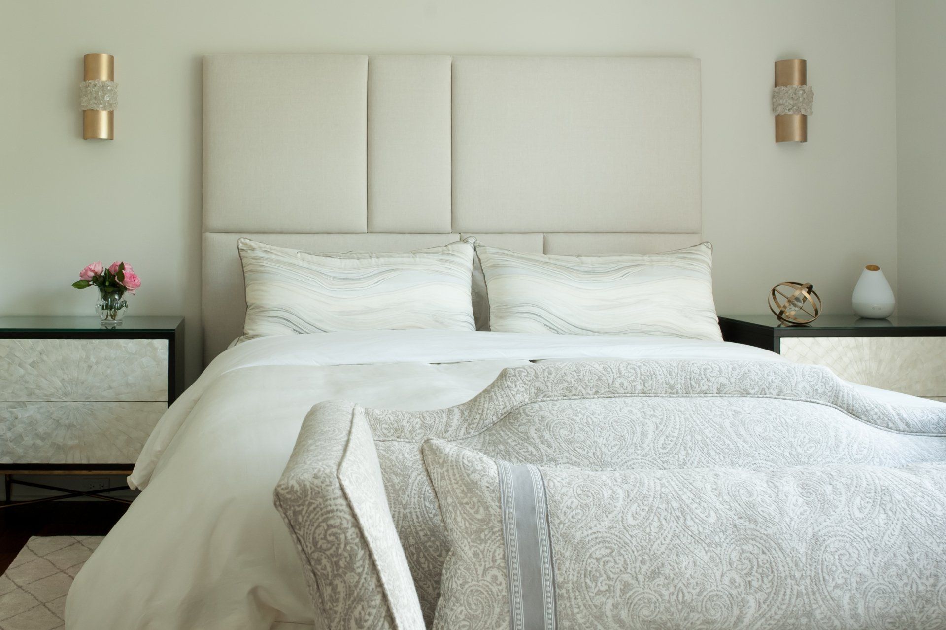 A bed with white sheets and pillows in a bedroom
