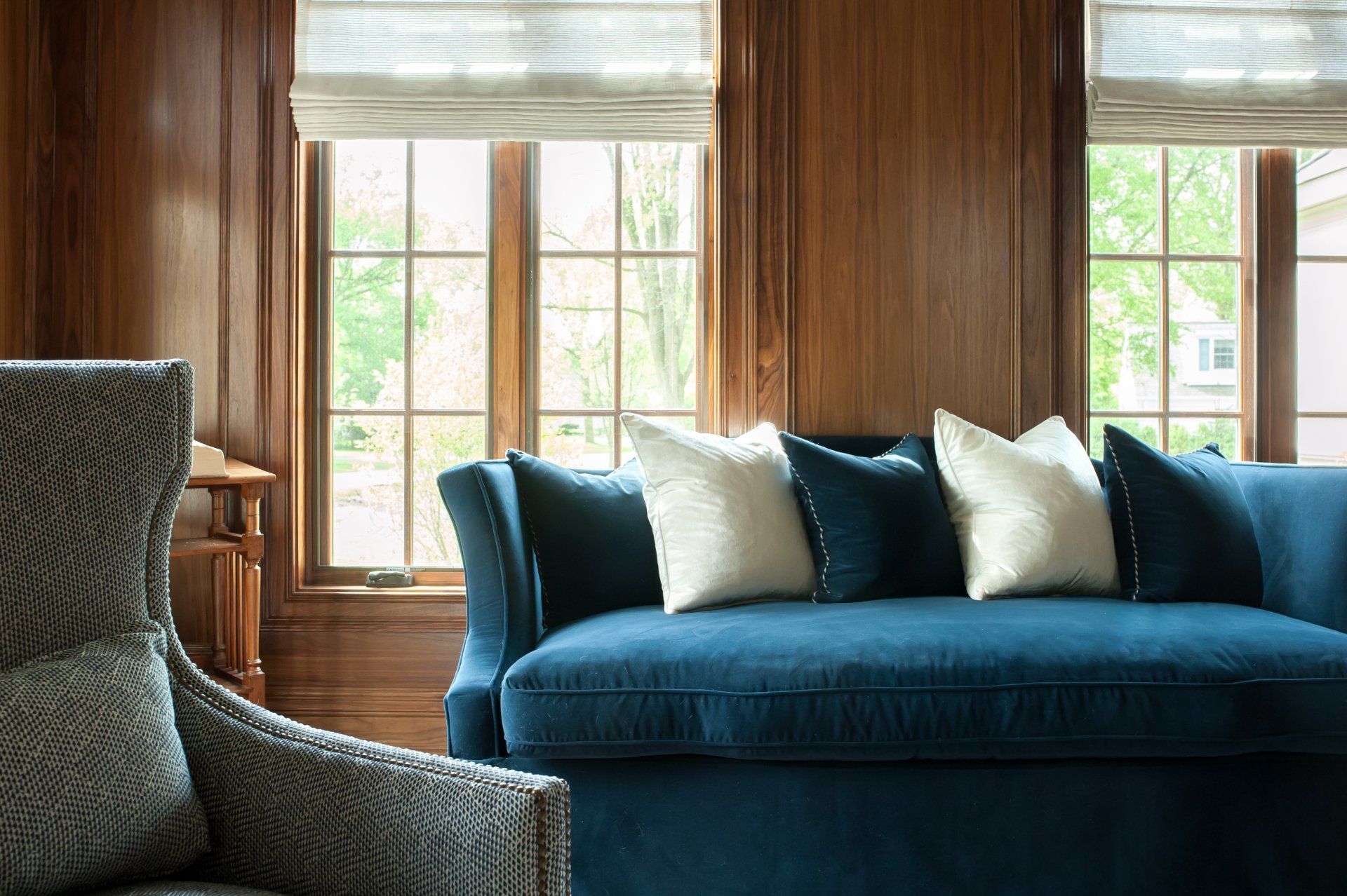 A living room with a blue couch and a chair.