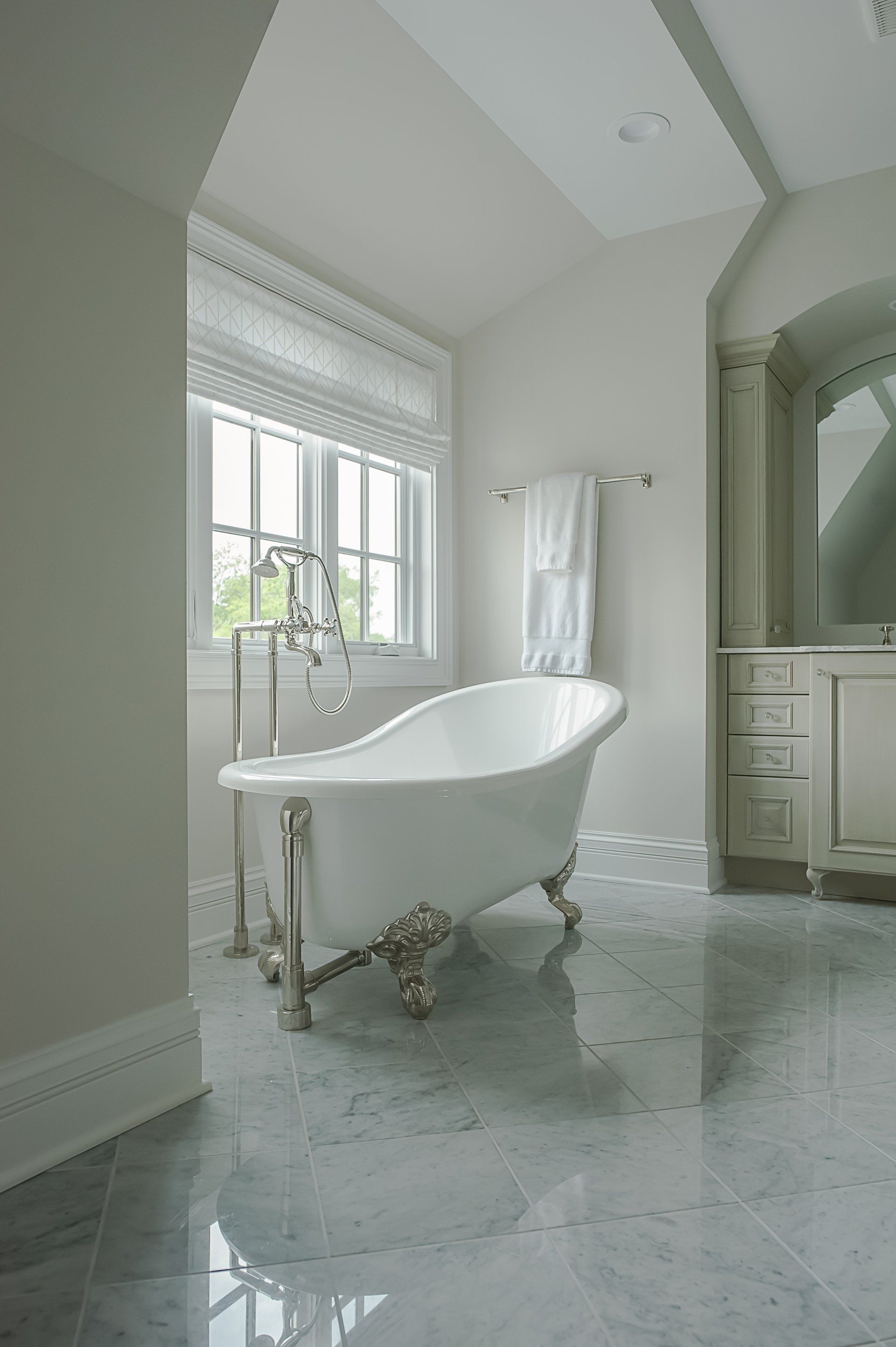A bathroom with a claw foot tub and a window.