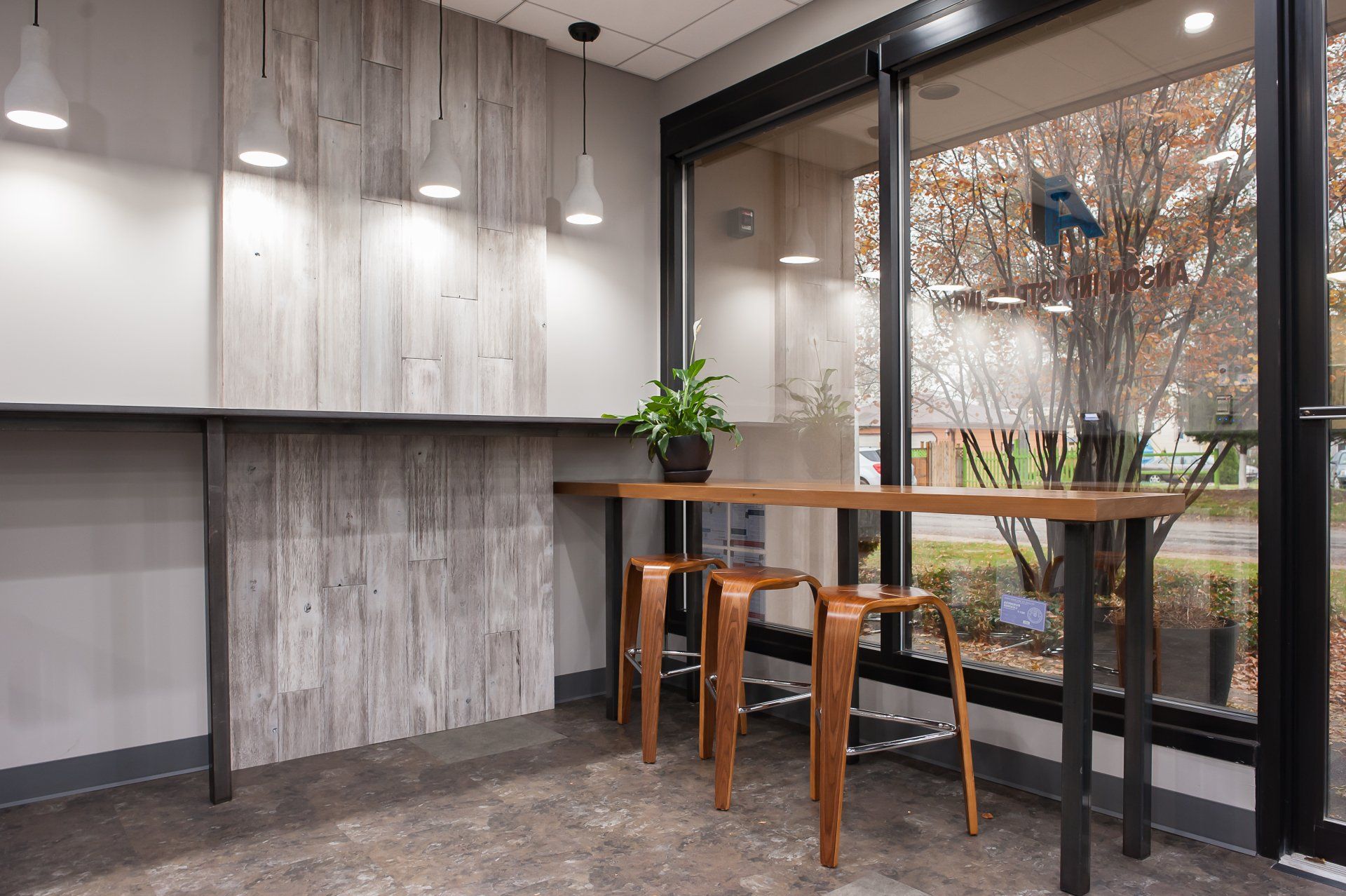 A room with a table and stools in front of a window.