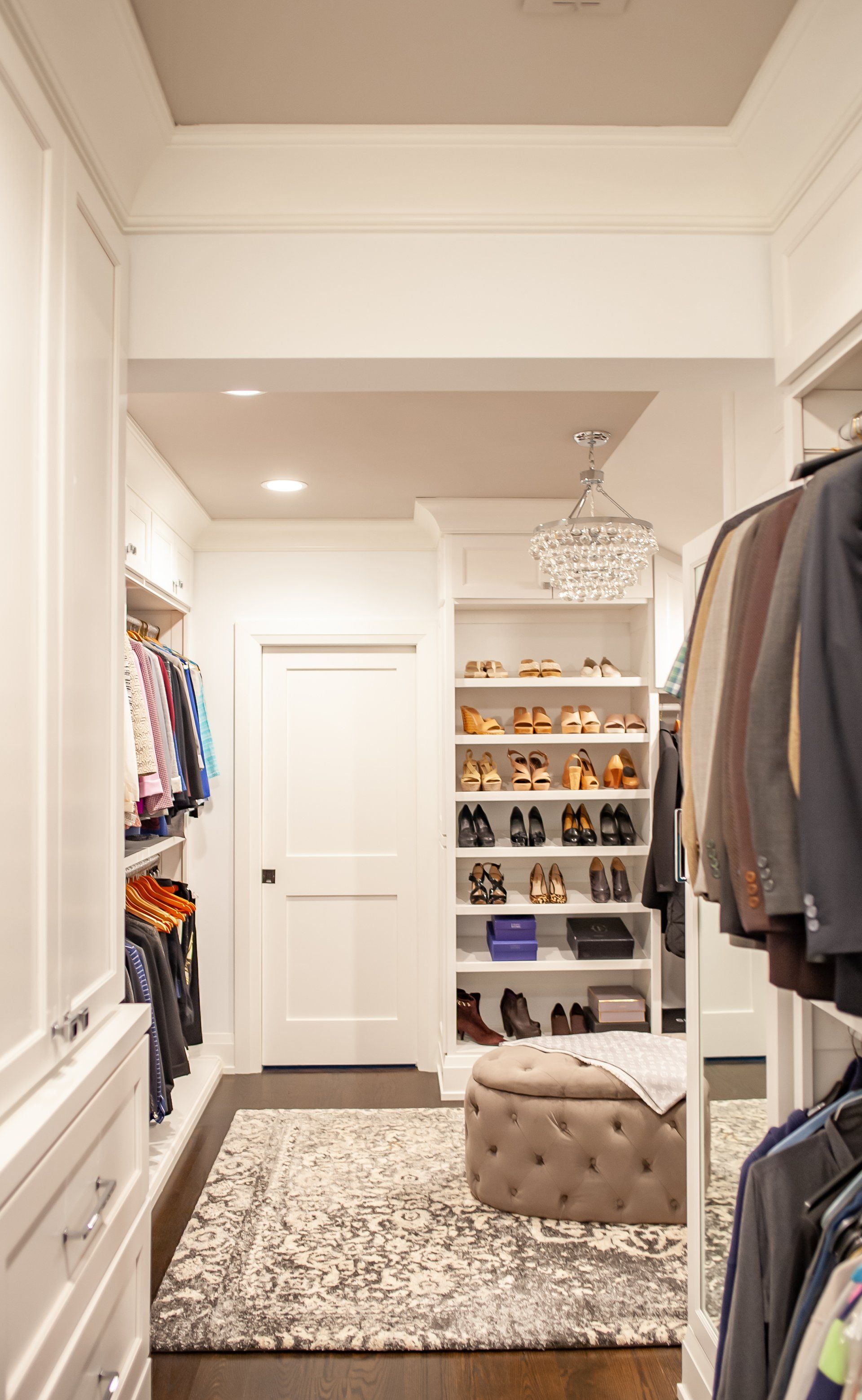 A walk in closet filled with lots of clothes and shoes.