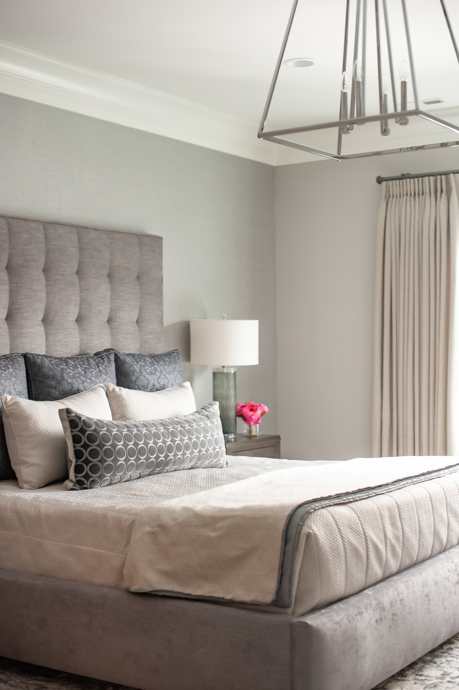 A bedroom with a large bed and a chandelier