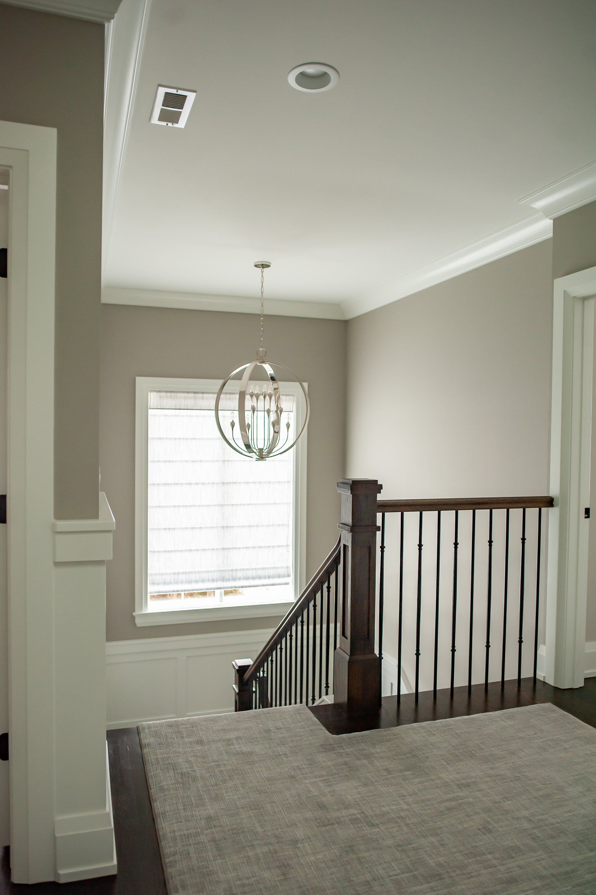 A staircase in a house with a chandelier hanging from the ceiling.