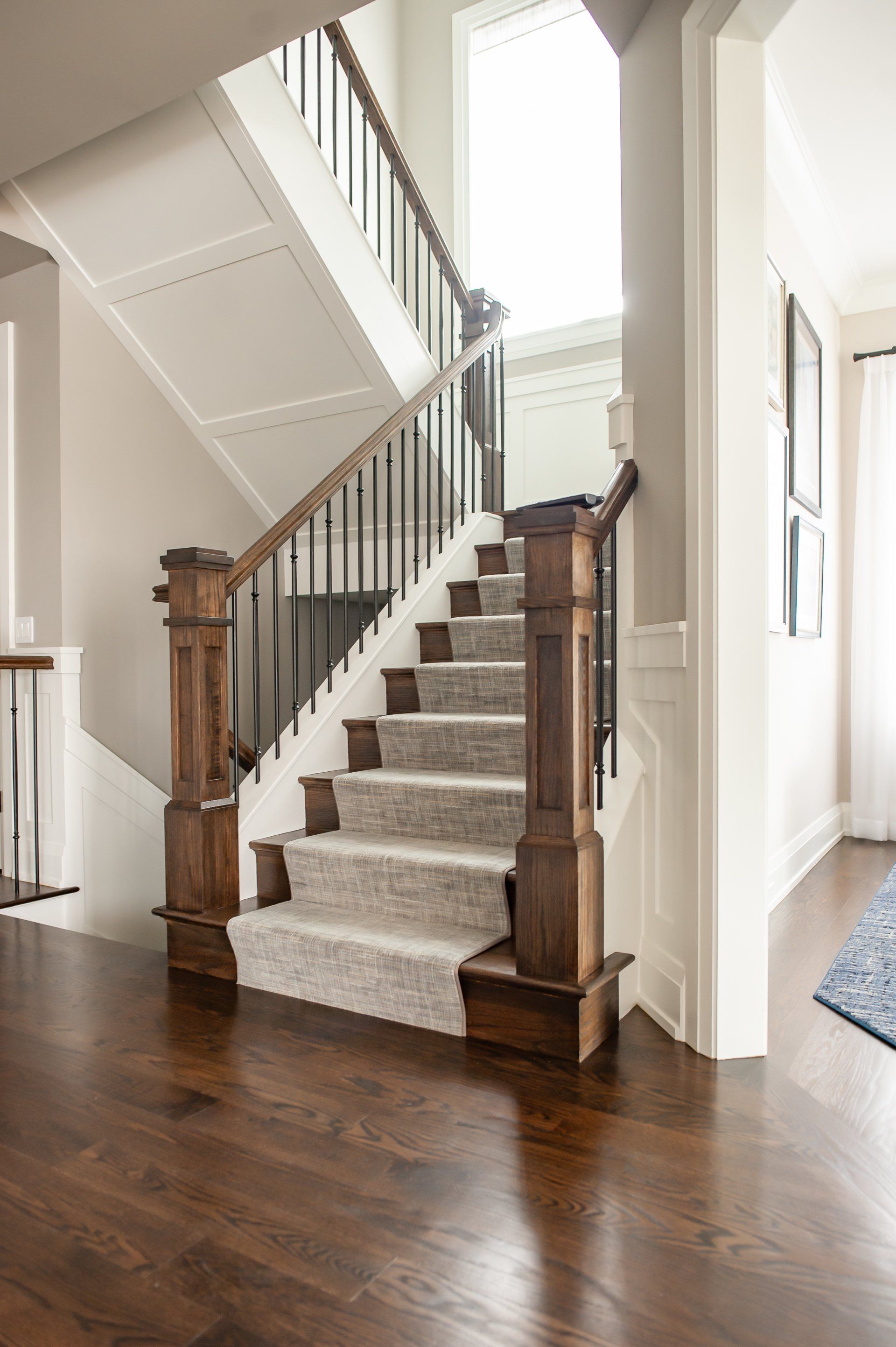 A staircase with a wooden railing and a carpeted staircase in a house.