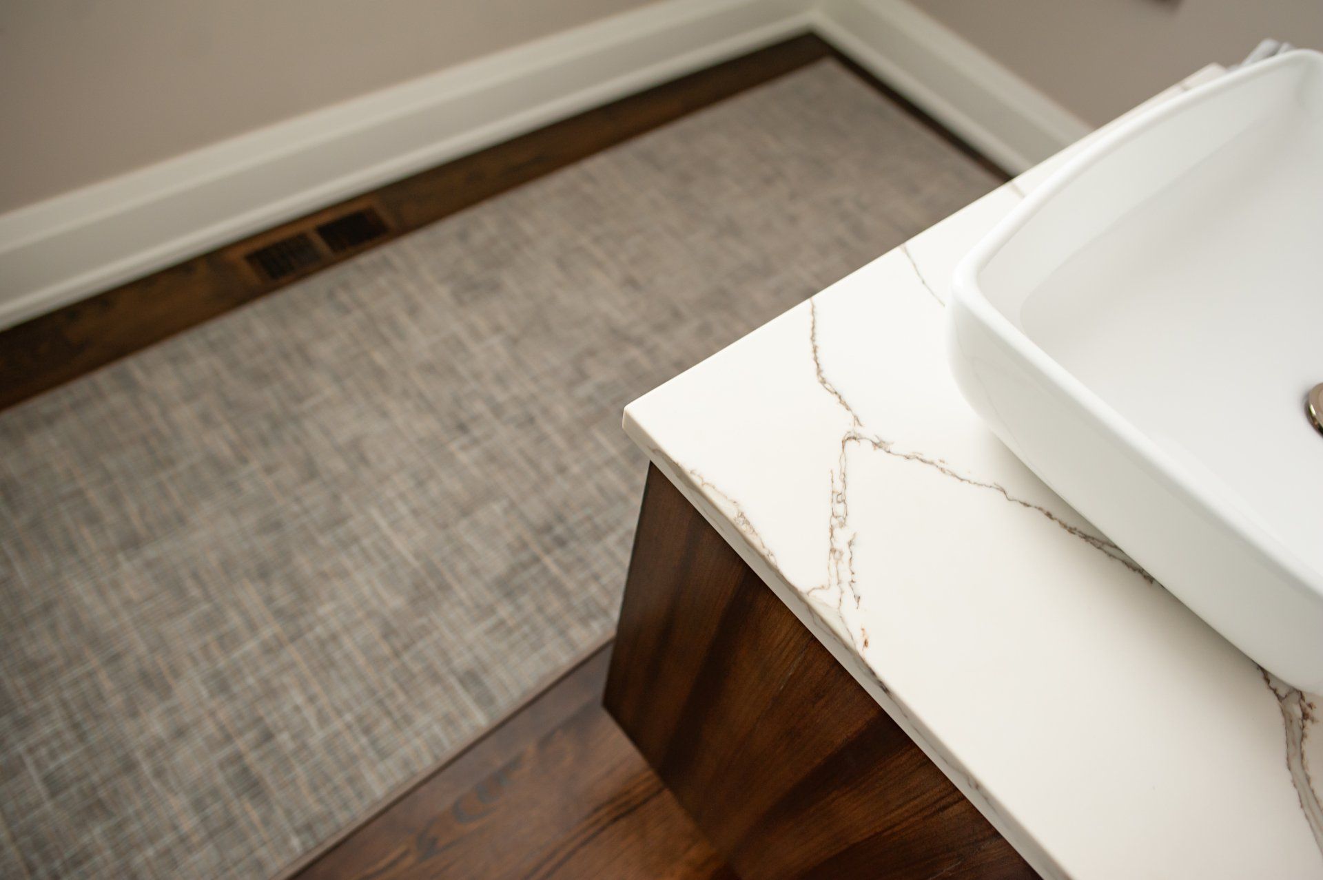 A bathroom with a sink and a rug on the floor.