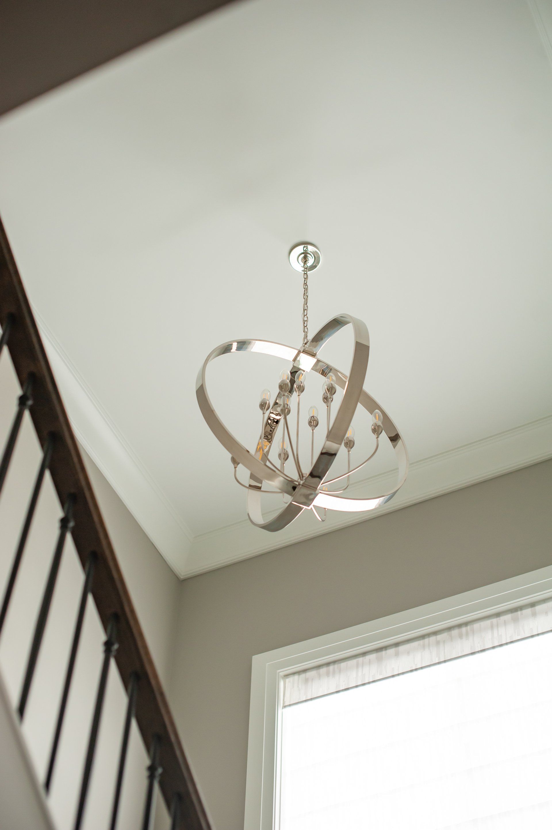 A chandelier is hanging from the ceiling above a staircase.