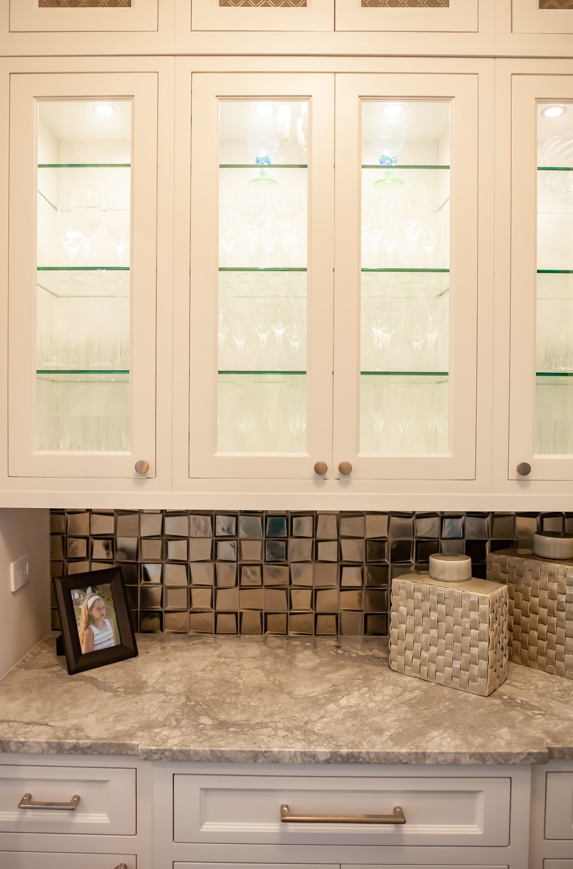 A kitchen with white cabinets and a picture on the counter.