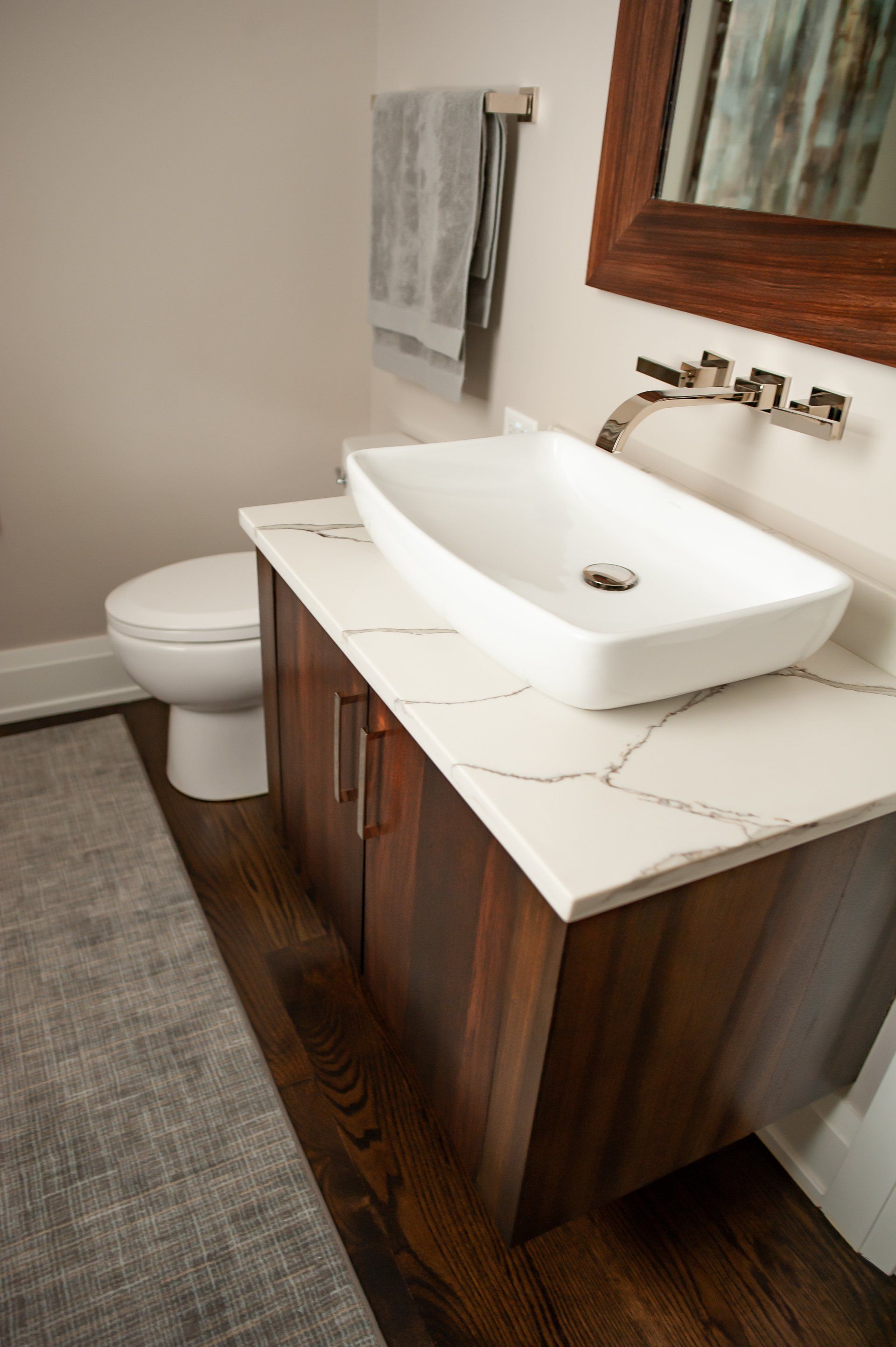 A bathroom with a sink , toilet and mirror.