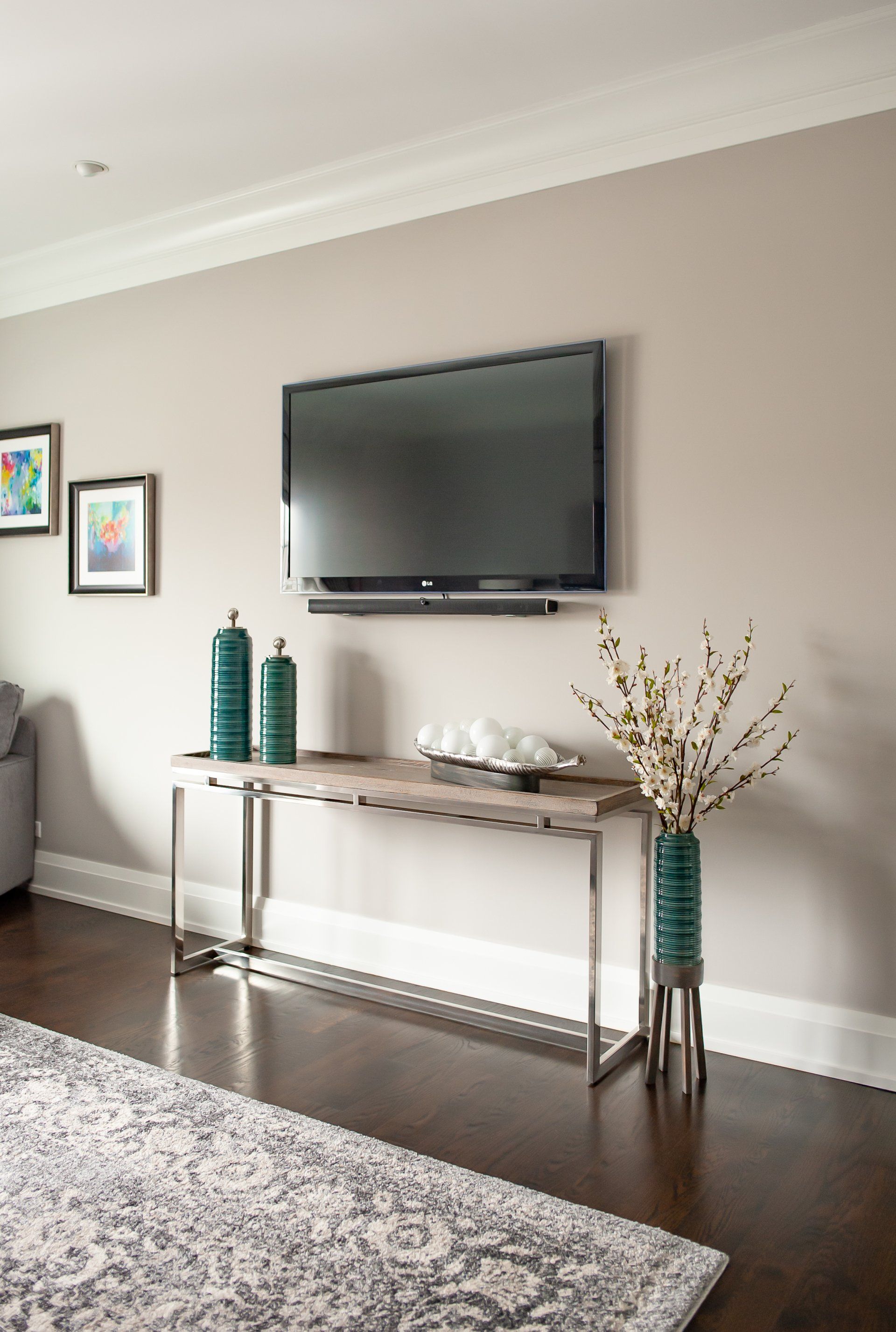 A living room with a flat screen tv mounted on the wall.