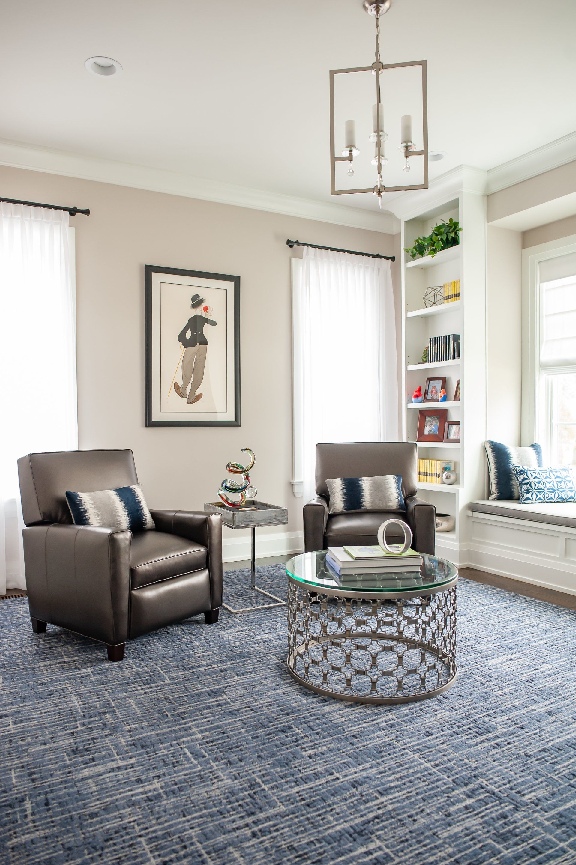 A living room with two chairs , a coffee table , and a window seat.