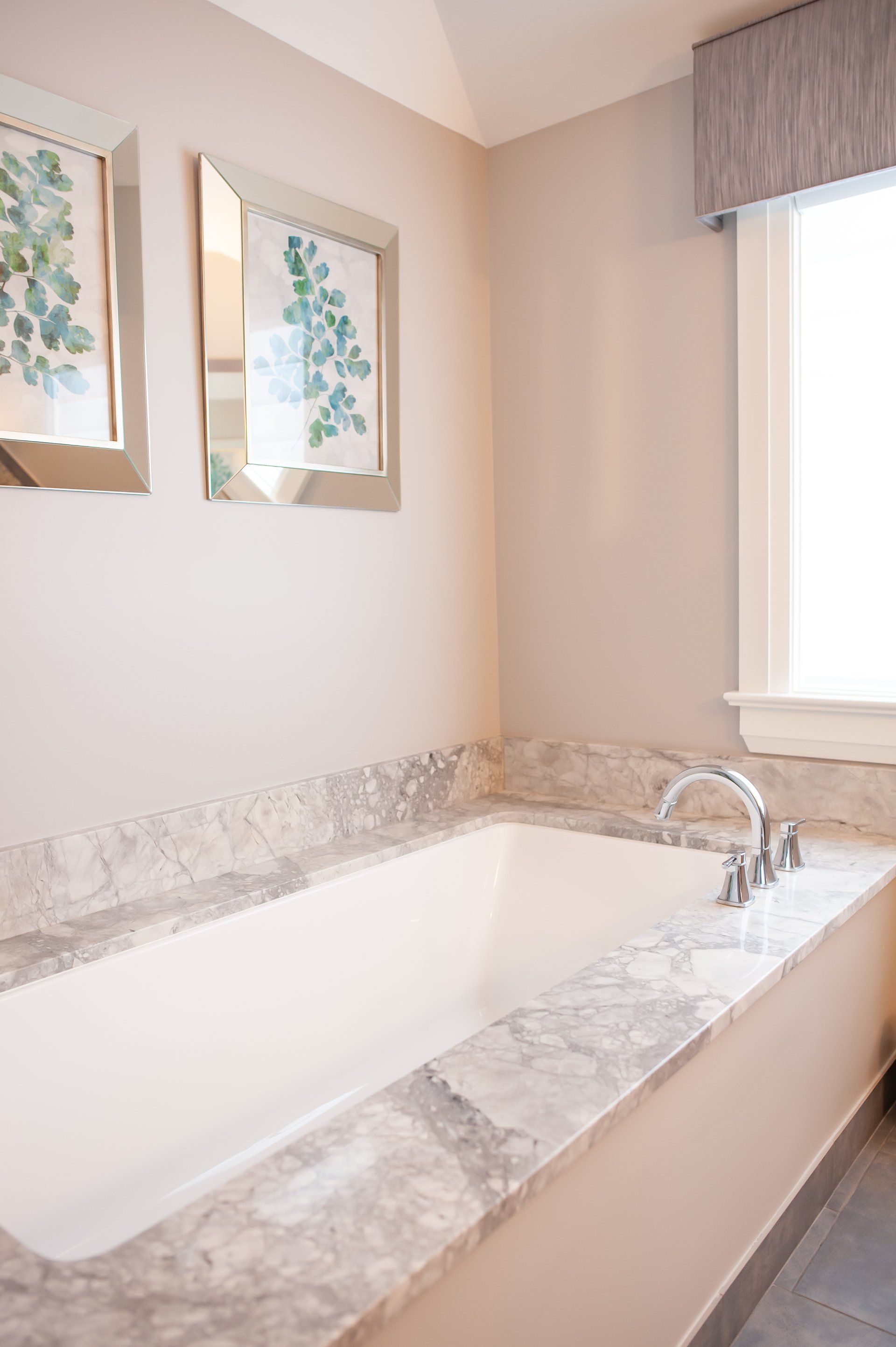 A bathroom with a bathtub and two mirrors on the wall.