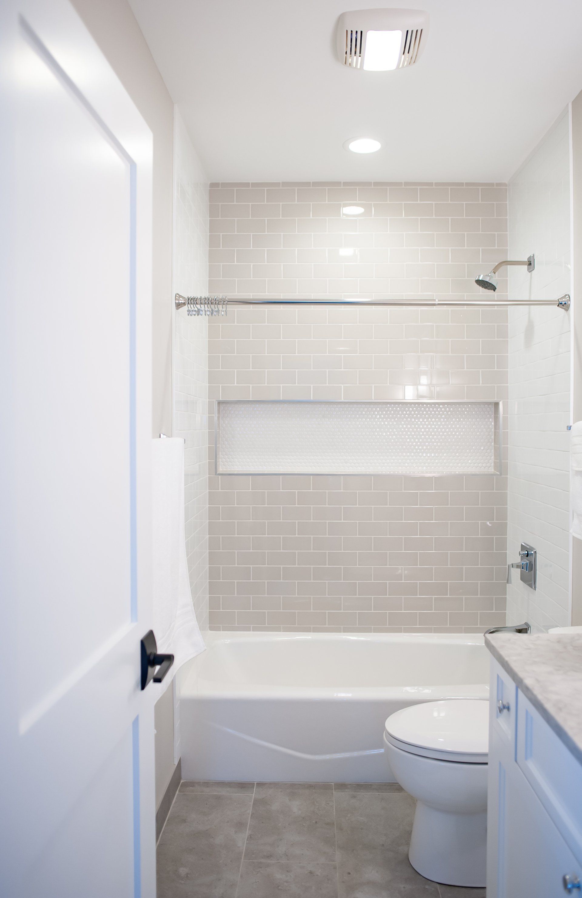A bathroom with a toilet , bathtub and shower.