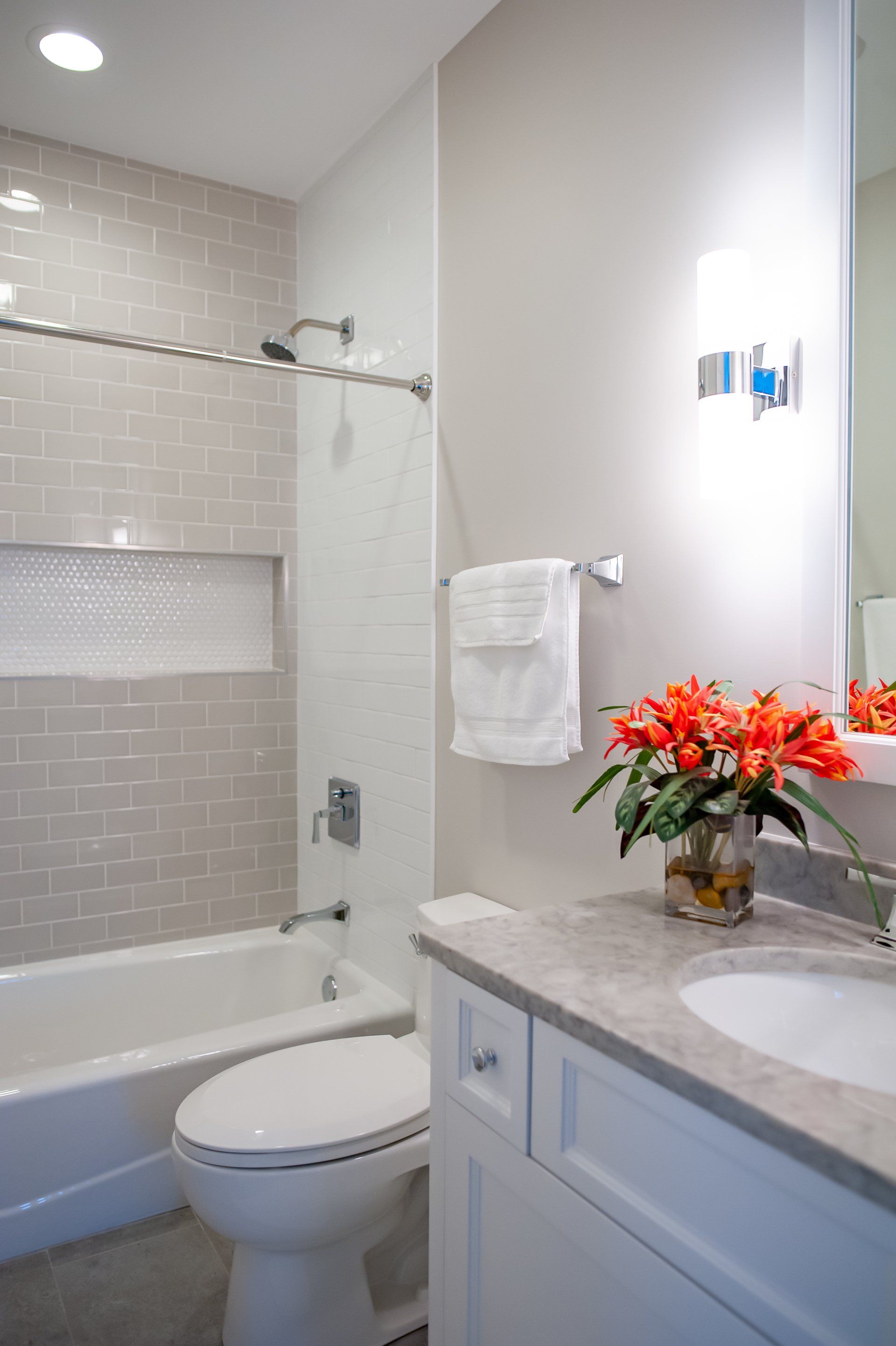 A bathroom with a toilet , sink , tub and mirror