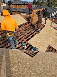 A group of construction workers are working on a roof.