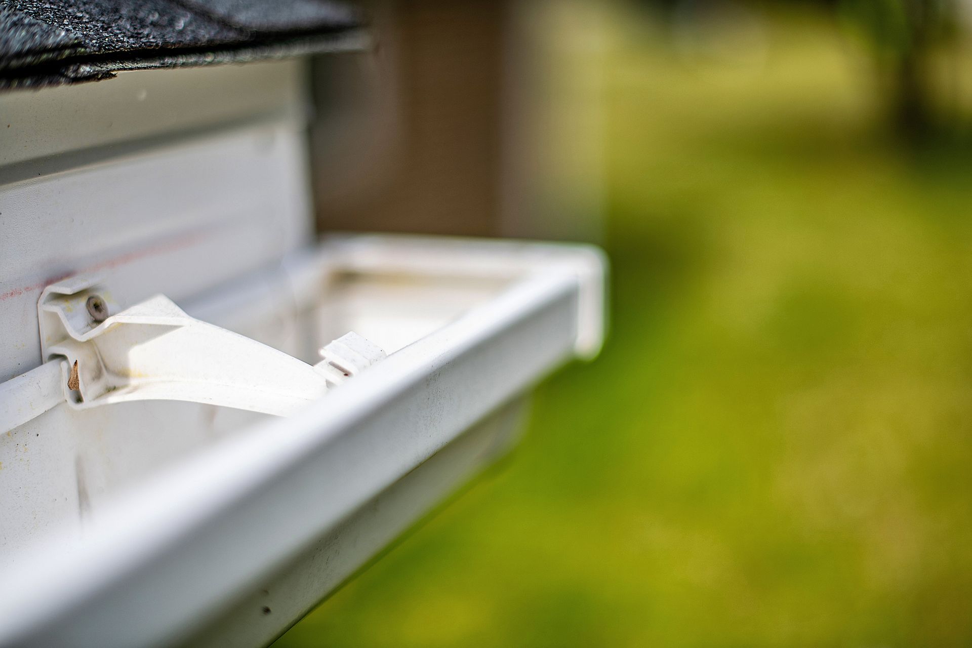 A close up of a white gutter on the side of a house.