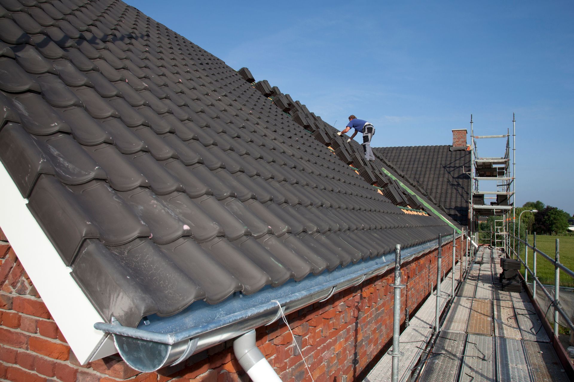 A man is working on the roof of a house