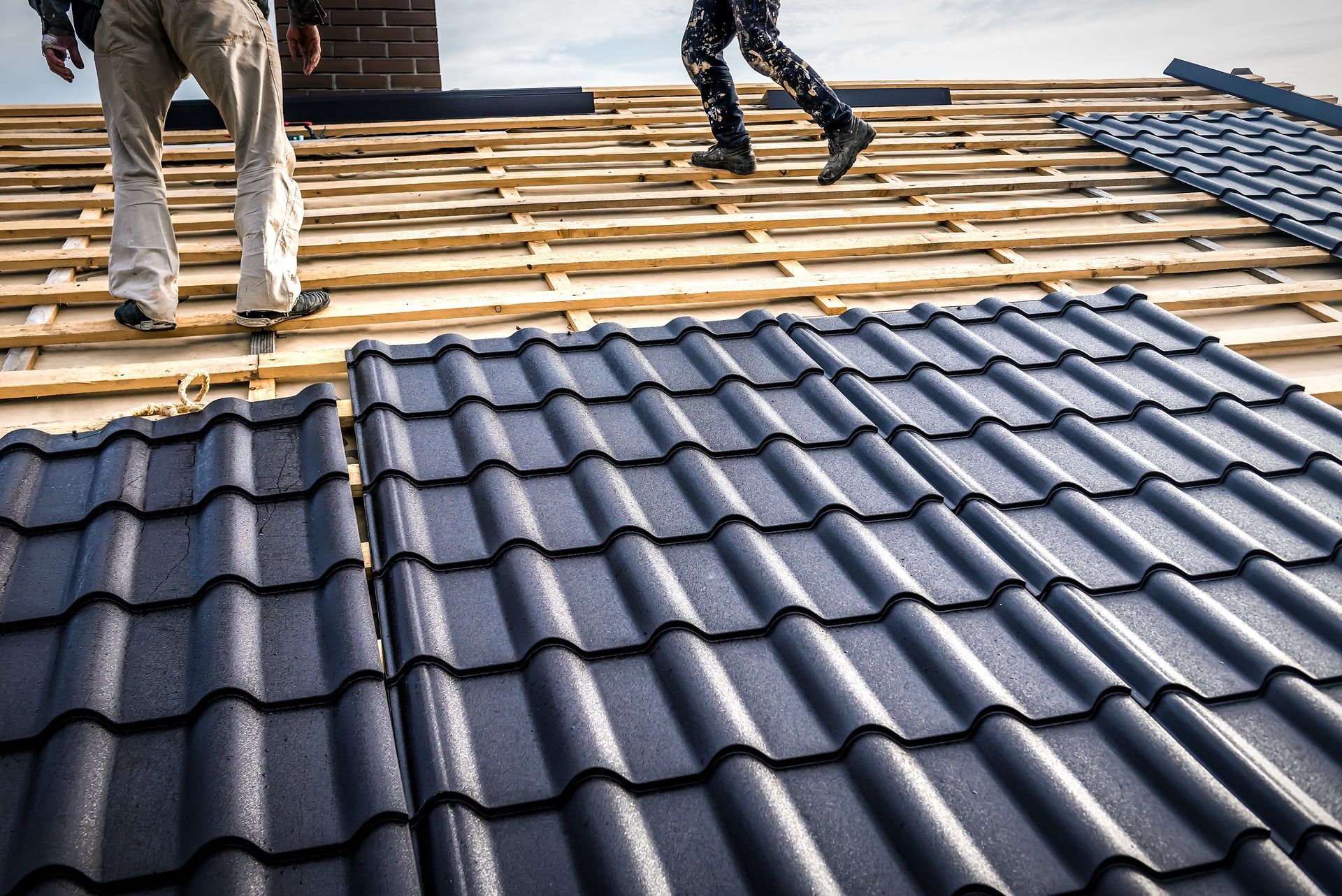 Two men are working on the roof of a house.