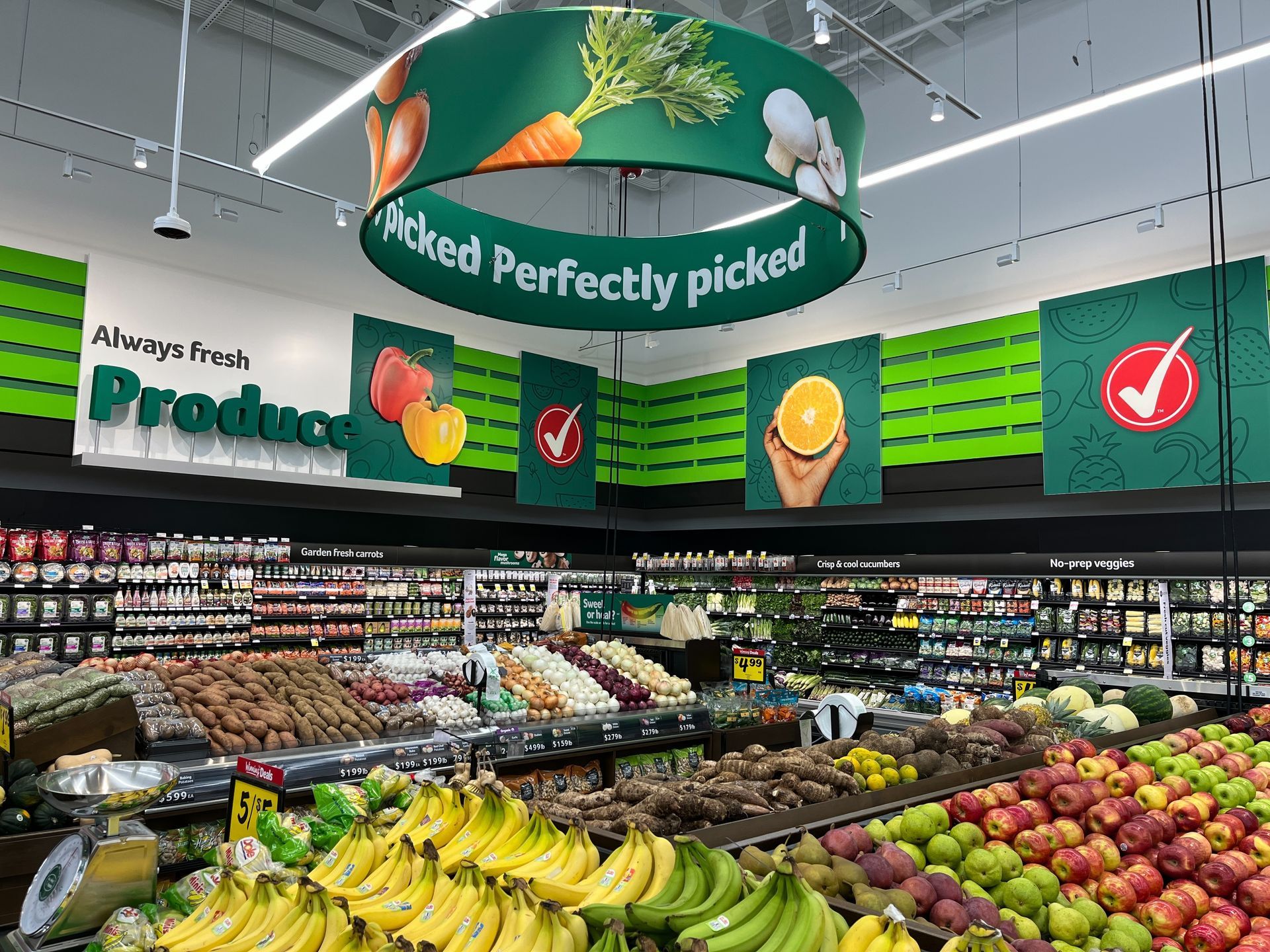 Bright grocery produce aisle with bananas, apples, and green 