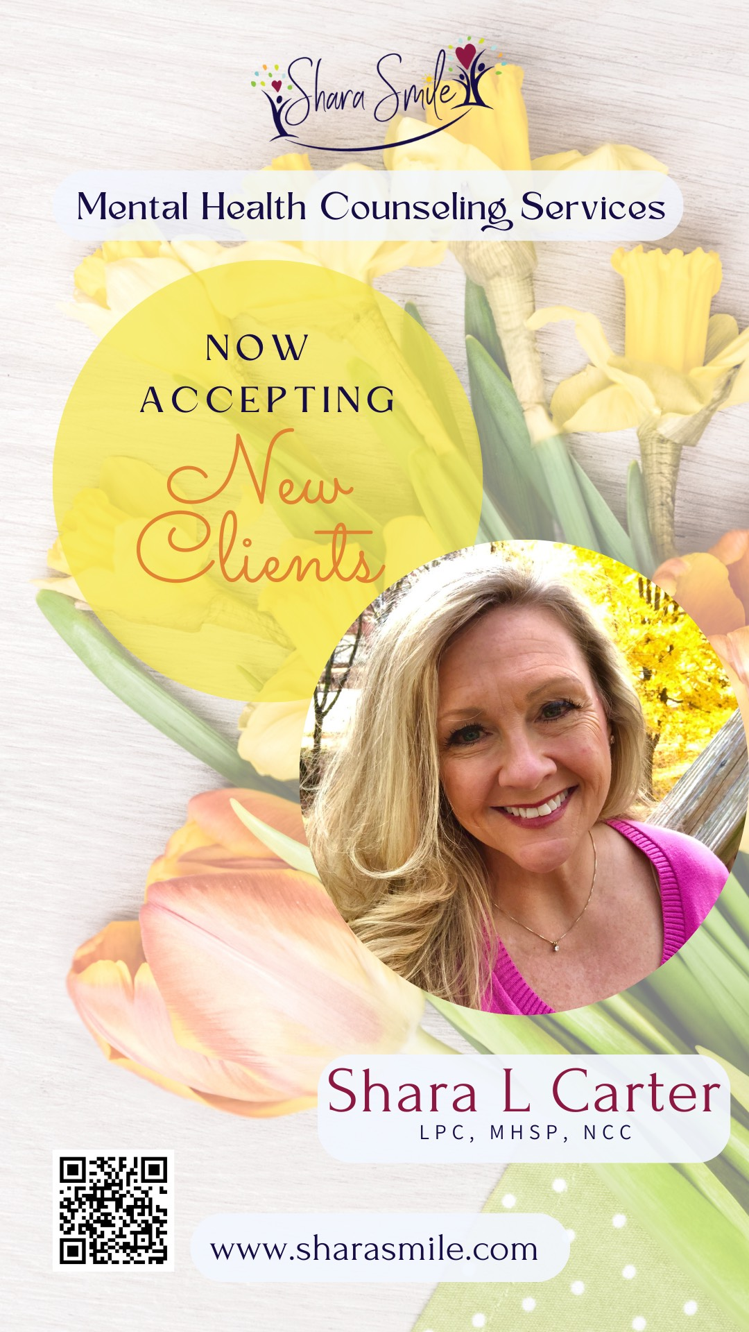 A woman is smiling in front of a bouquet of flowers.