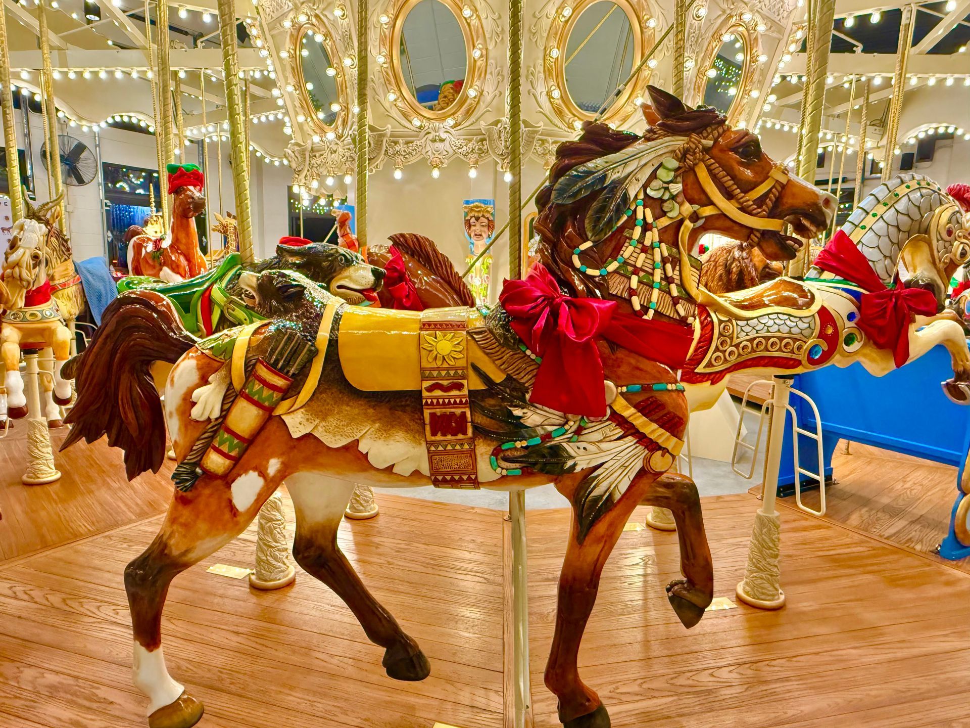 People walking outdoors at an event, many wearing blue shirts, some holding signs on a sunny day.