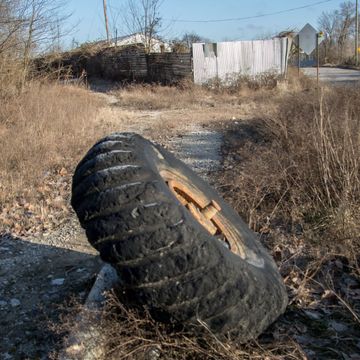 A tire with a hole in it is laying on the ground