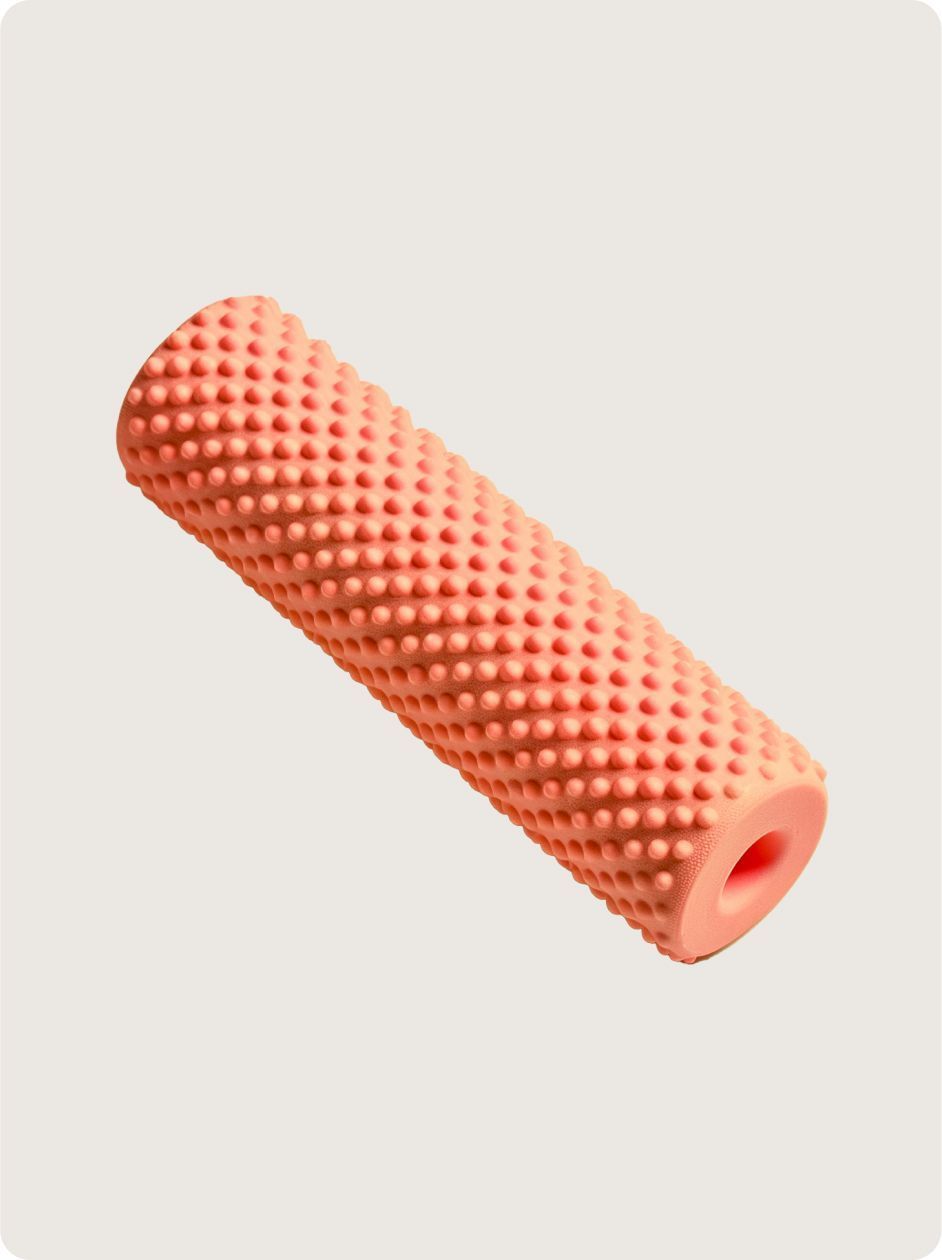 A pink rubber roller with a hole in the middle on a white background.