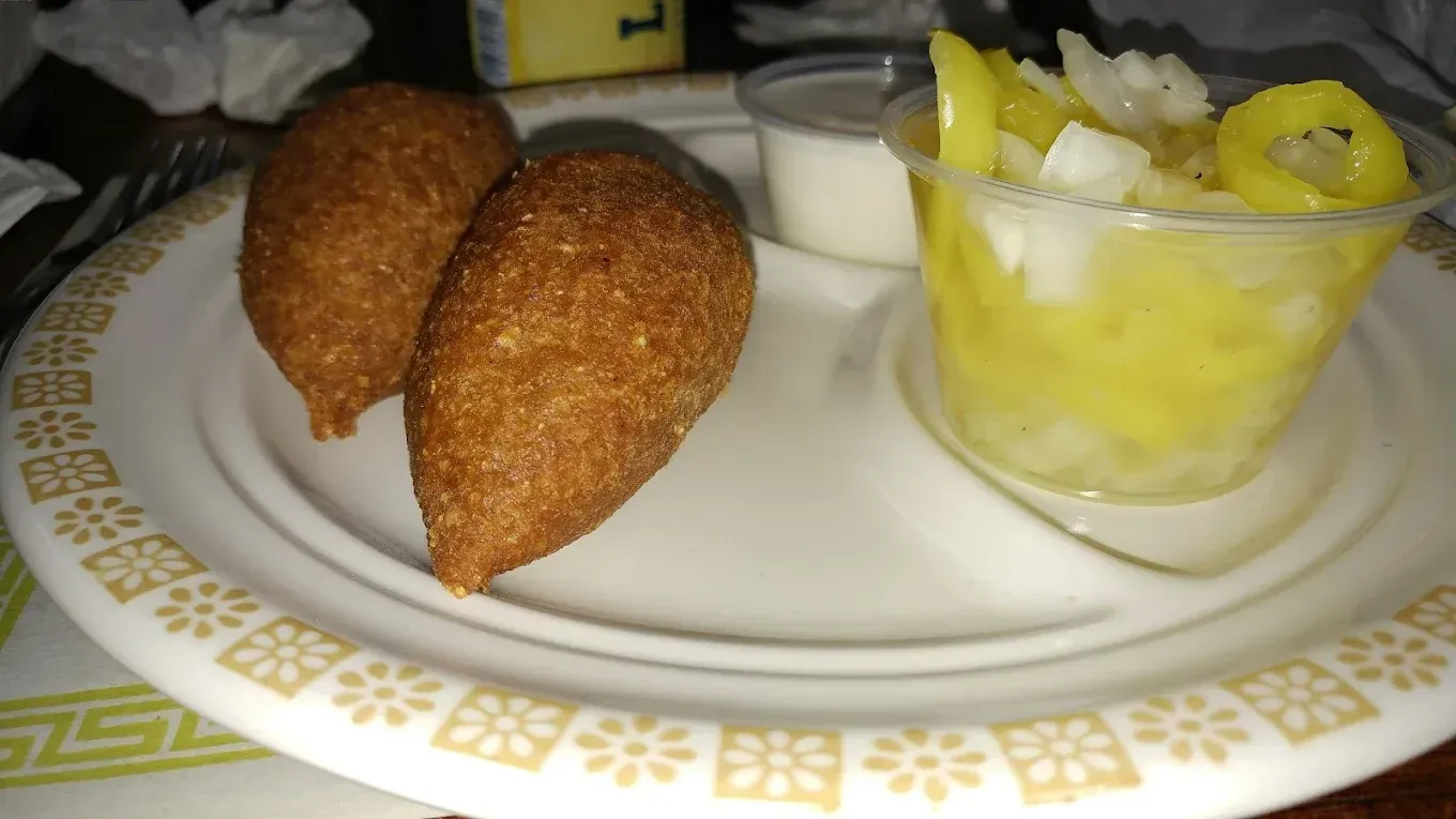 A plate of food with a cup of fruit on it.