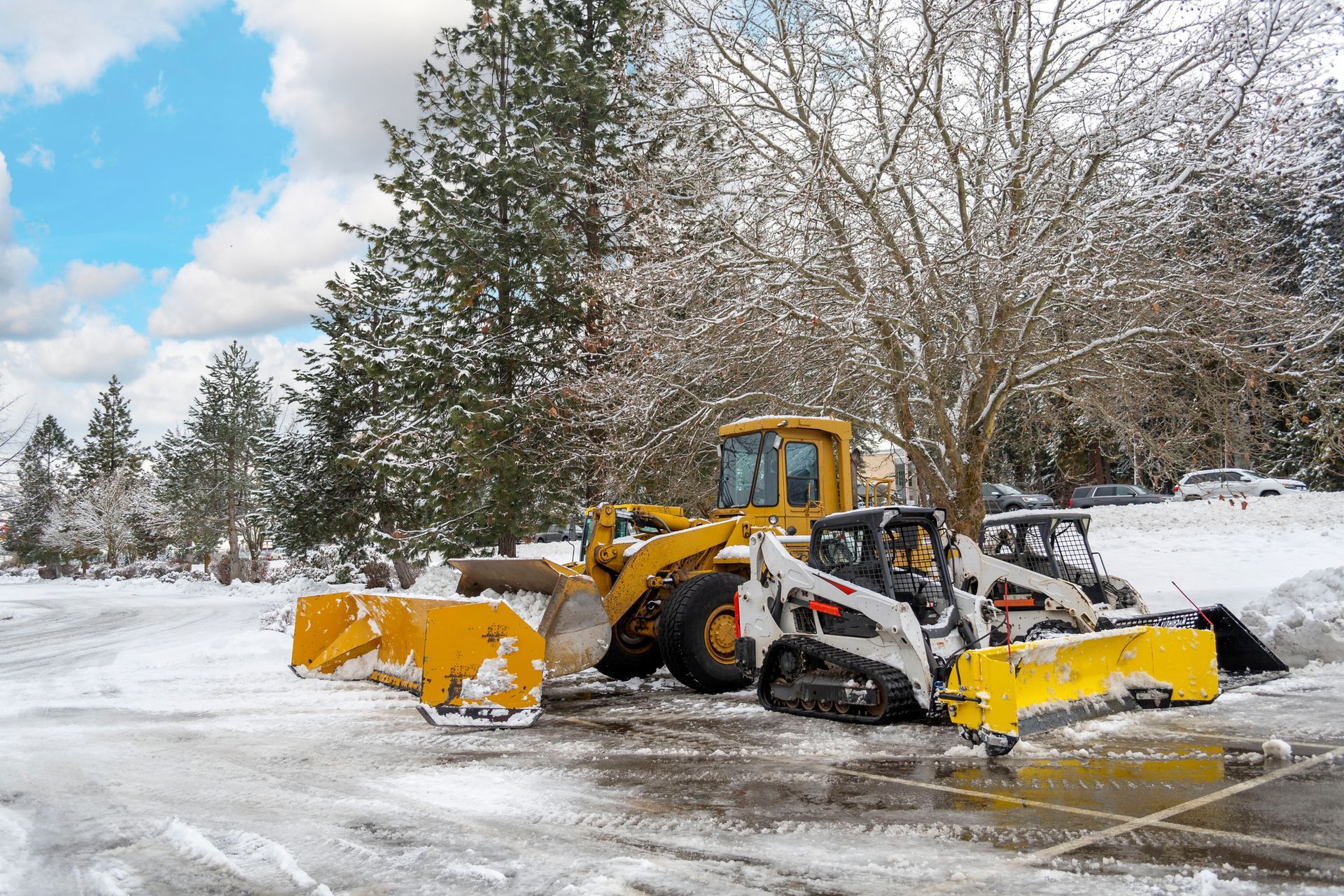 A Couple of Snow Plows Are Parked in A Parking Lot | Onalaska, WI | River City Irrigation