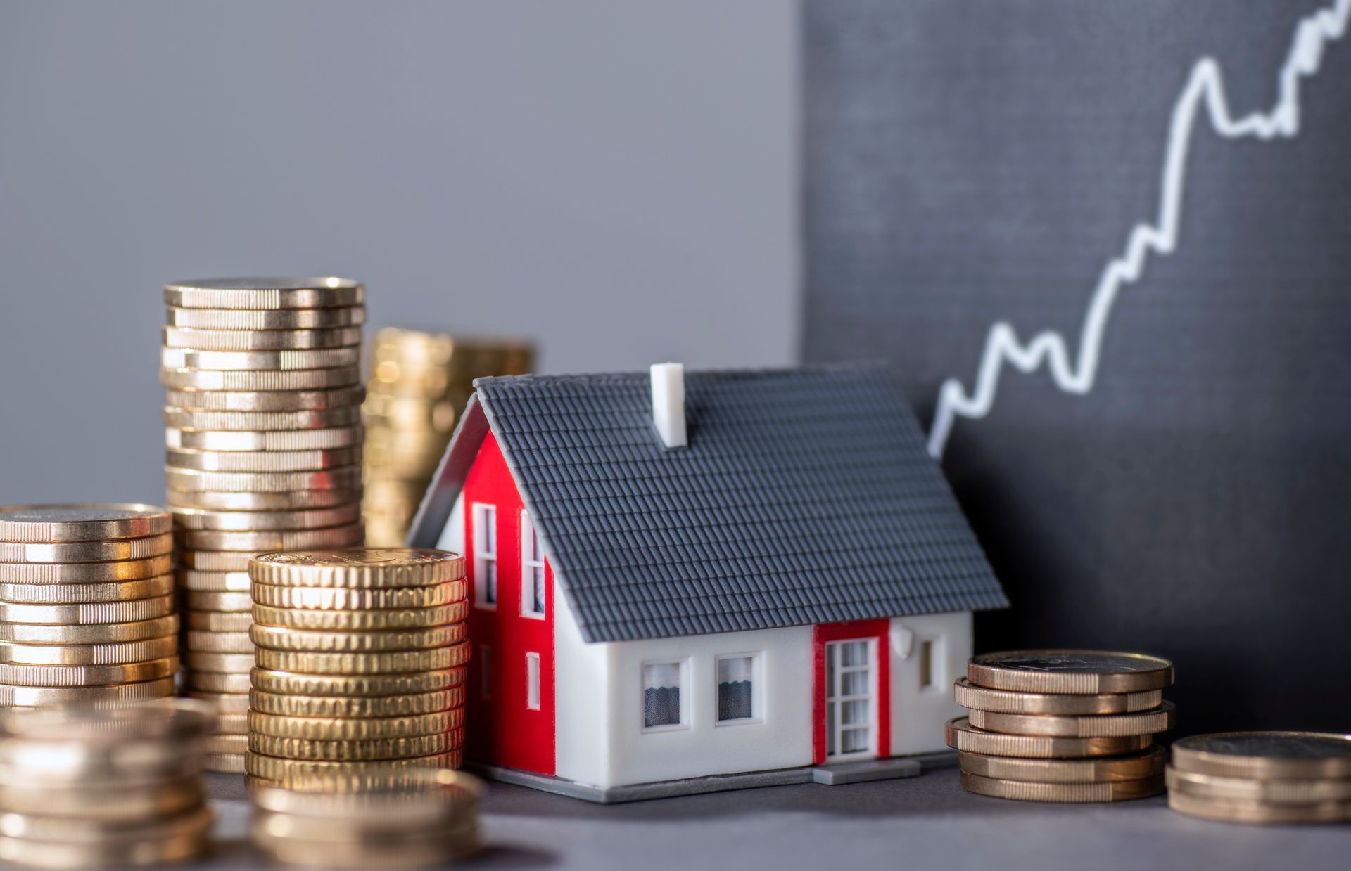 A Model House Is Sitting Next to Stacks of Coins | Onalaska, WI | River City Irrigation