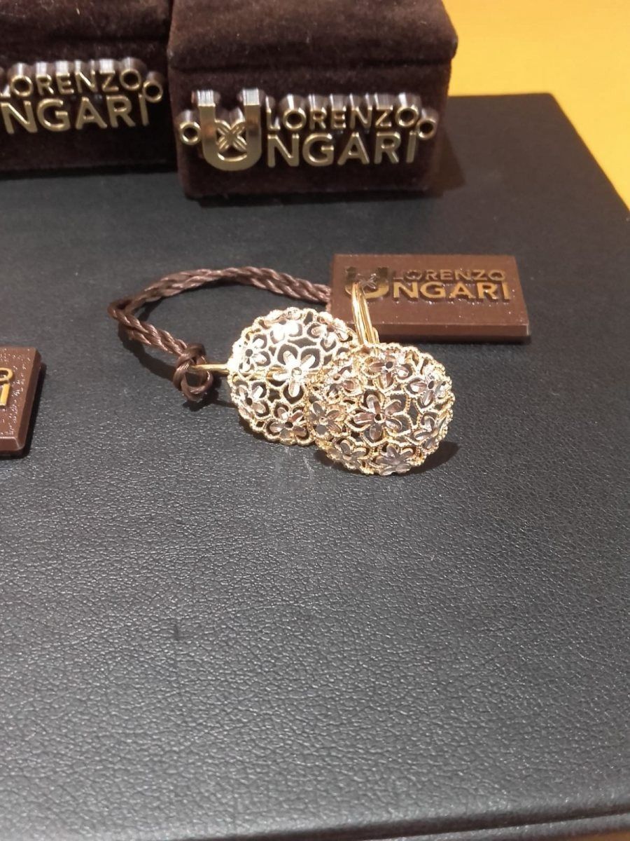 Orecchini a sfera in oro, etichetta marrone, superficie scura, scatola portagioie Lorenzo Ungari.