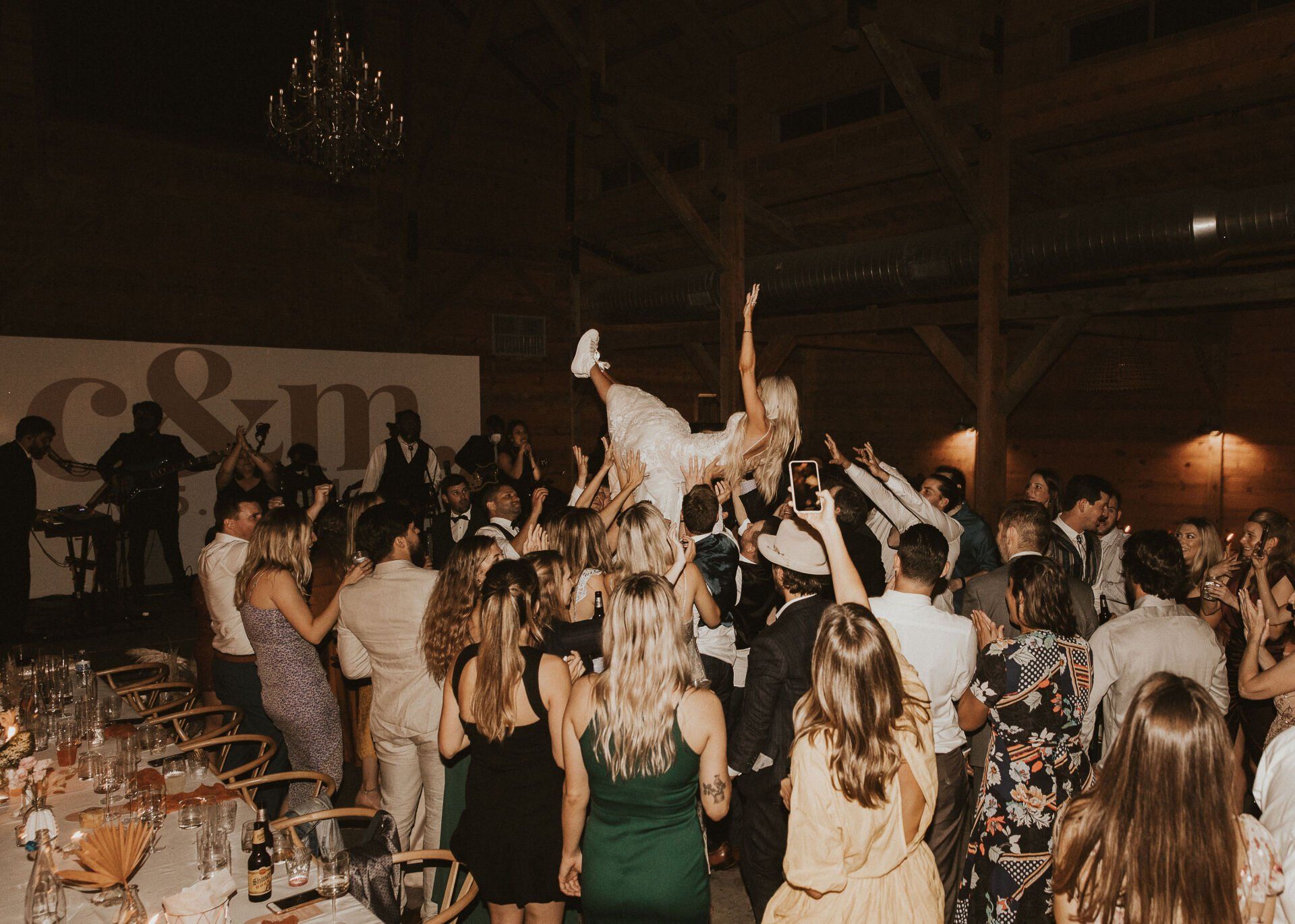 the bride crowdsurfing as the guests move her around inside at The Addison Grove in Austin, Texas Hill Country 