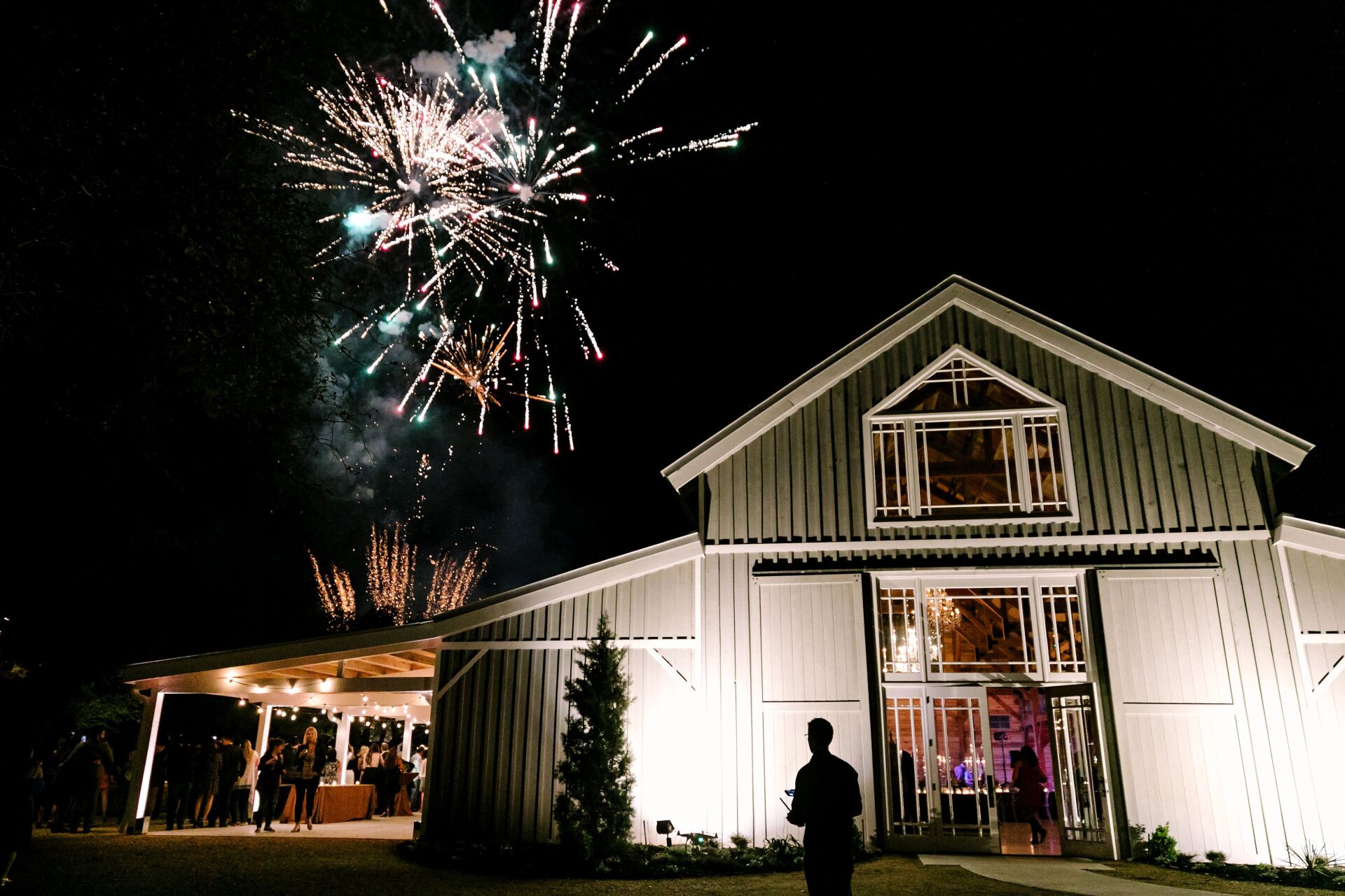 the barn at The Addison Grove in Austin, Texas with fireworks going off in the background Hill Country Wedding Venue